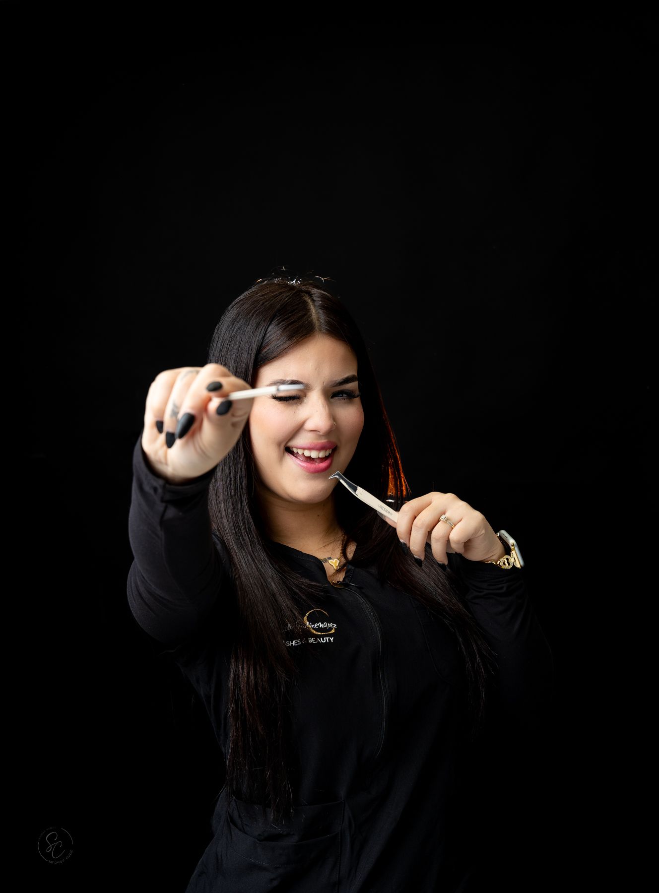Woman in dark clothing displays playful gestures during professional photo session.