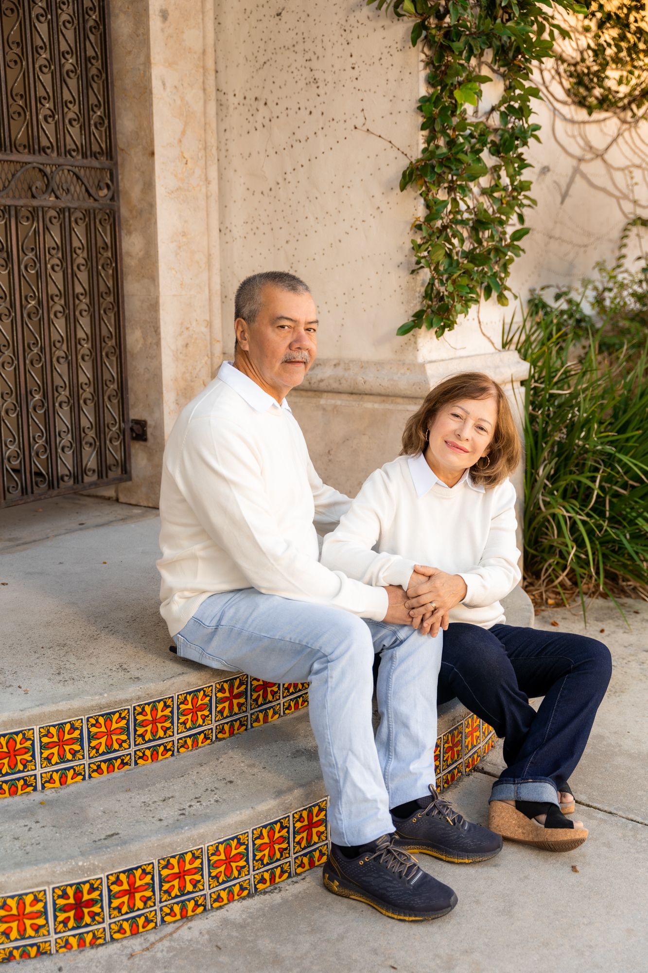 A series of photos showing two people sitting on decorative Spanish tile steps in white and navy outfits.