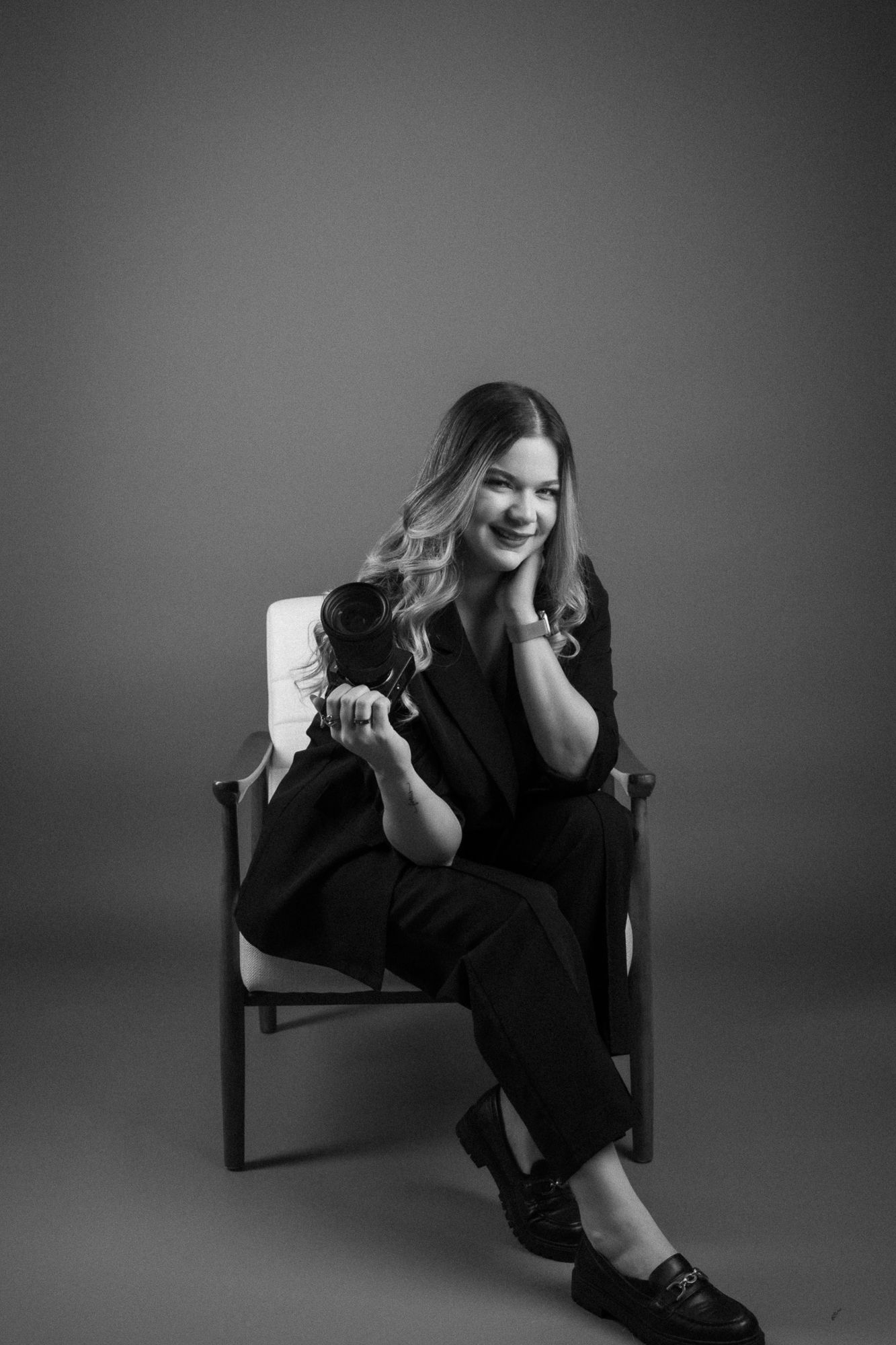 Black and white portrait series showing expressive poses in a chair against dark background.