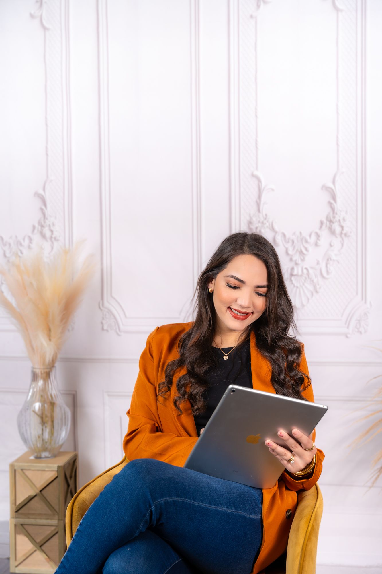 Casual business setting with person relaxing in armchair while using tablet.