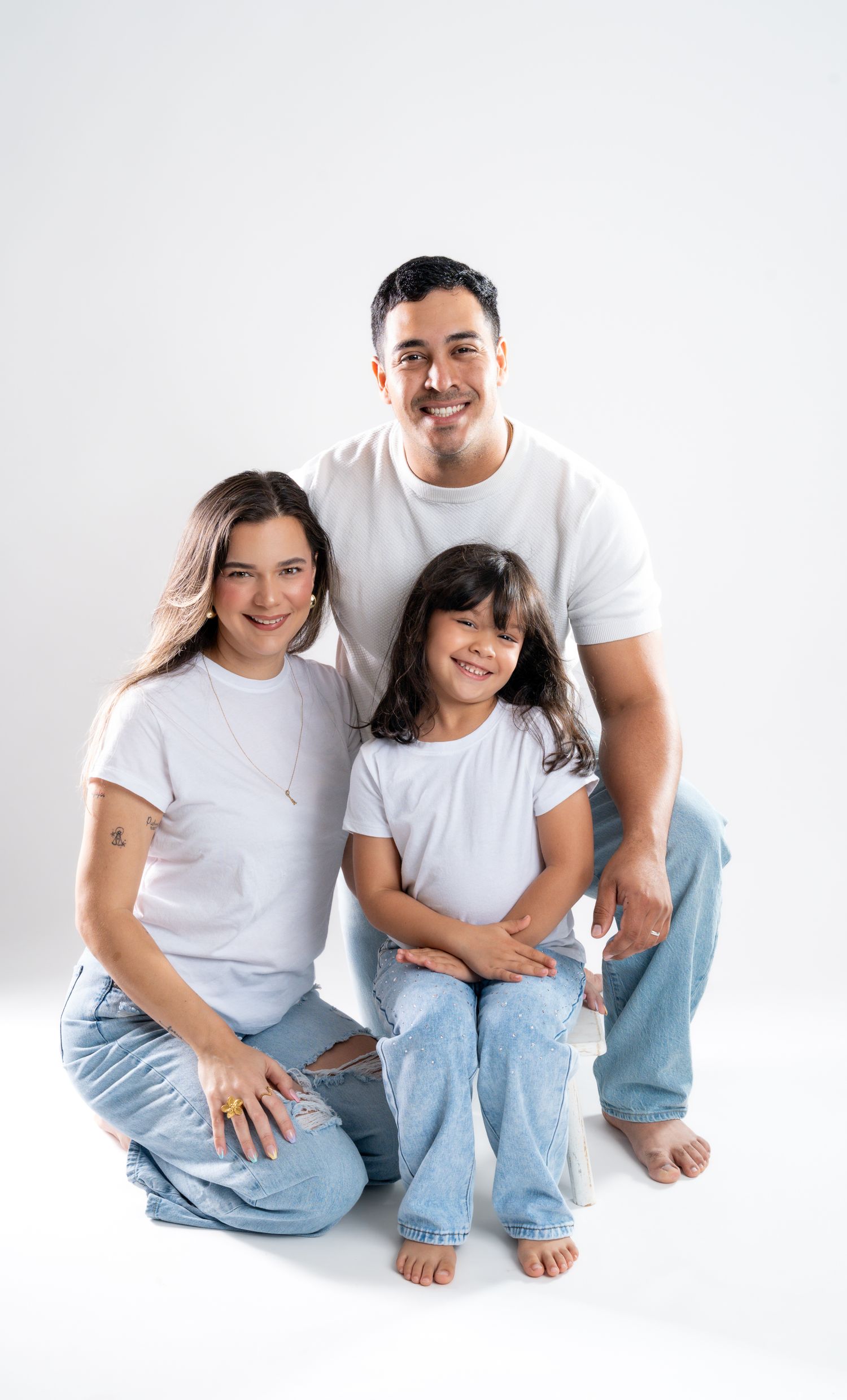 Candid family moments captured against white backdrop in matching casual wear.
