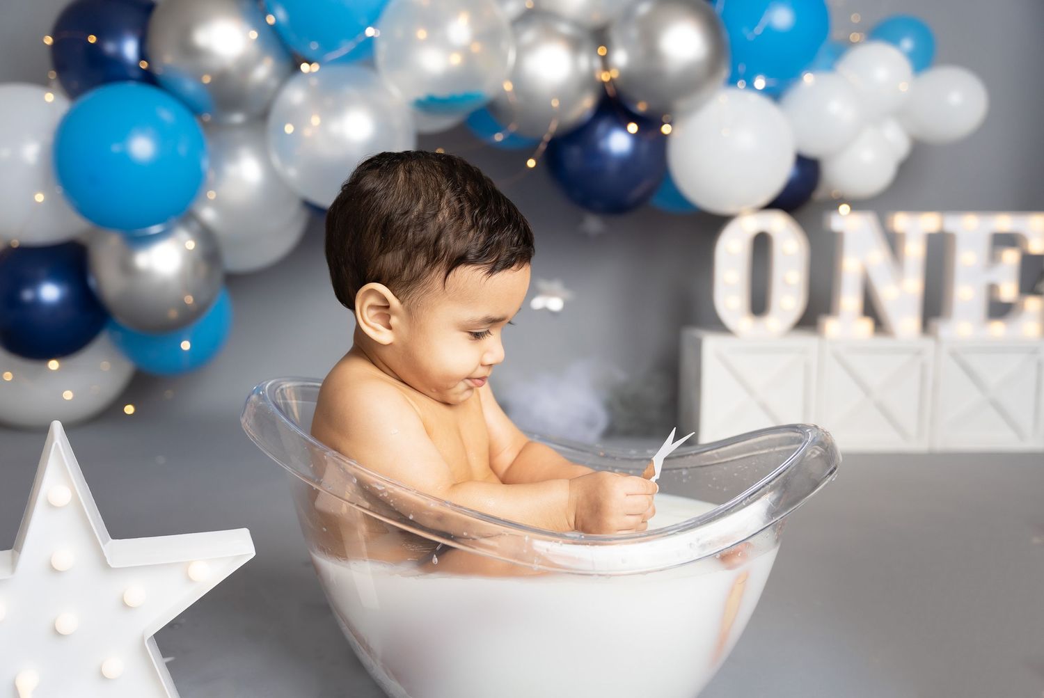 First birthday celebration setup with elegant balloon garland in blue, navy and silver.