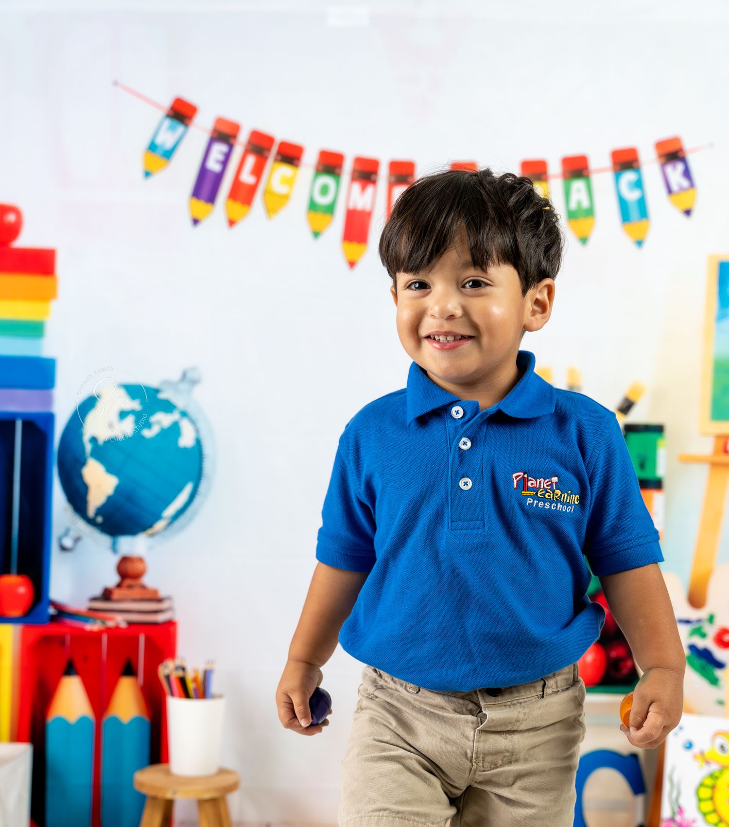 Cheerful preschool portraits in blue uniform polo showing playful expressions.
