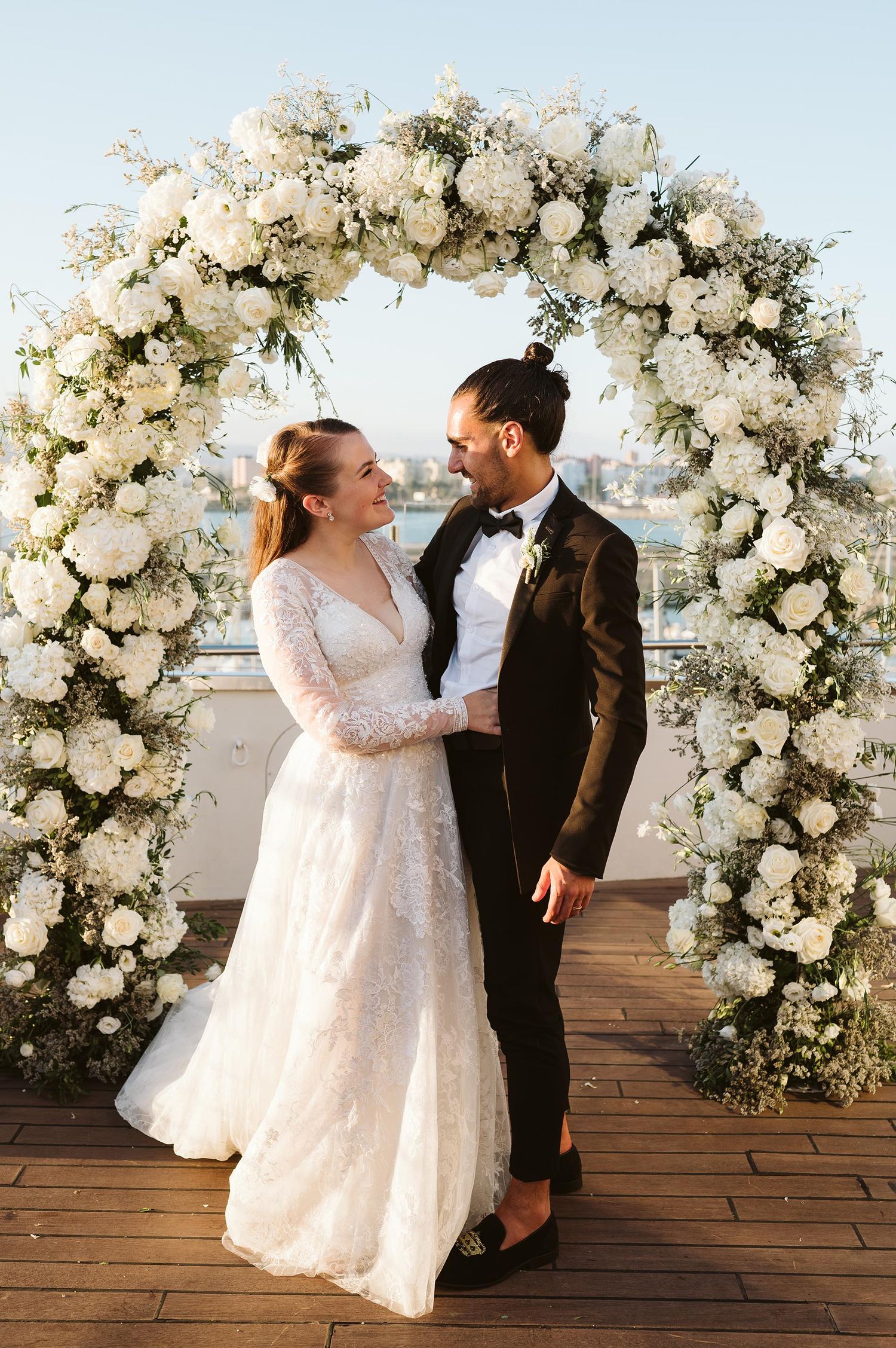 wedding couple holding each other on Sunborn Gibraltar under a flower arch