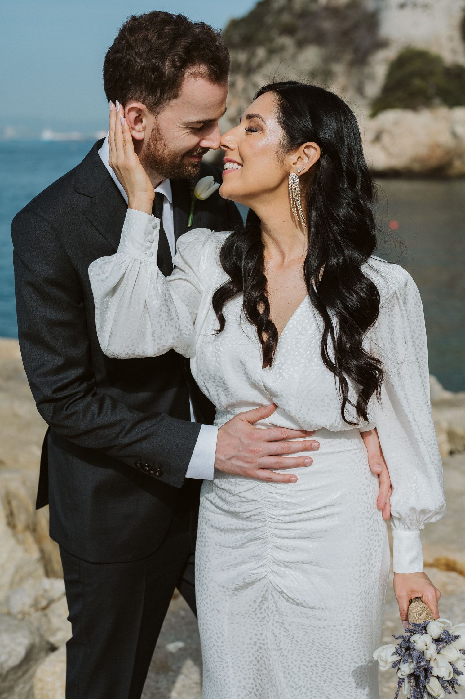 bride holding the face of the groom in a very romantic shot at the Rosia Bay in Gibraltar