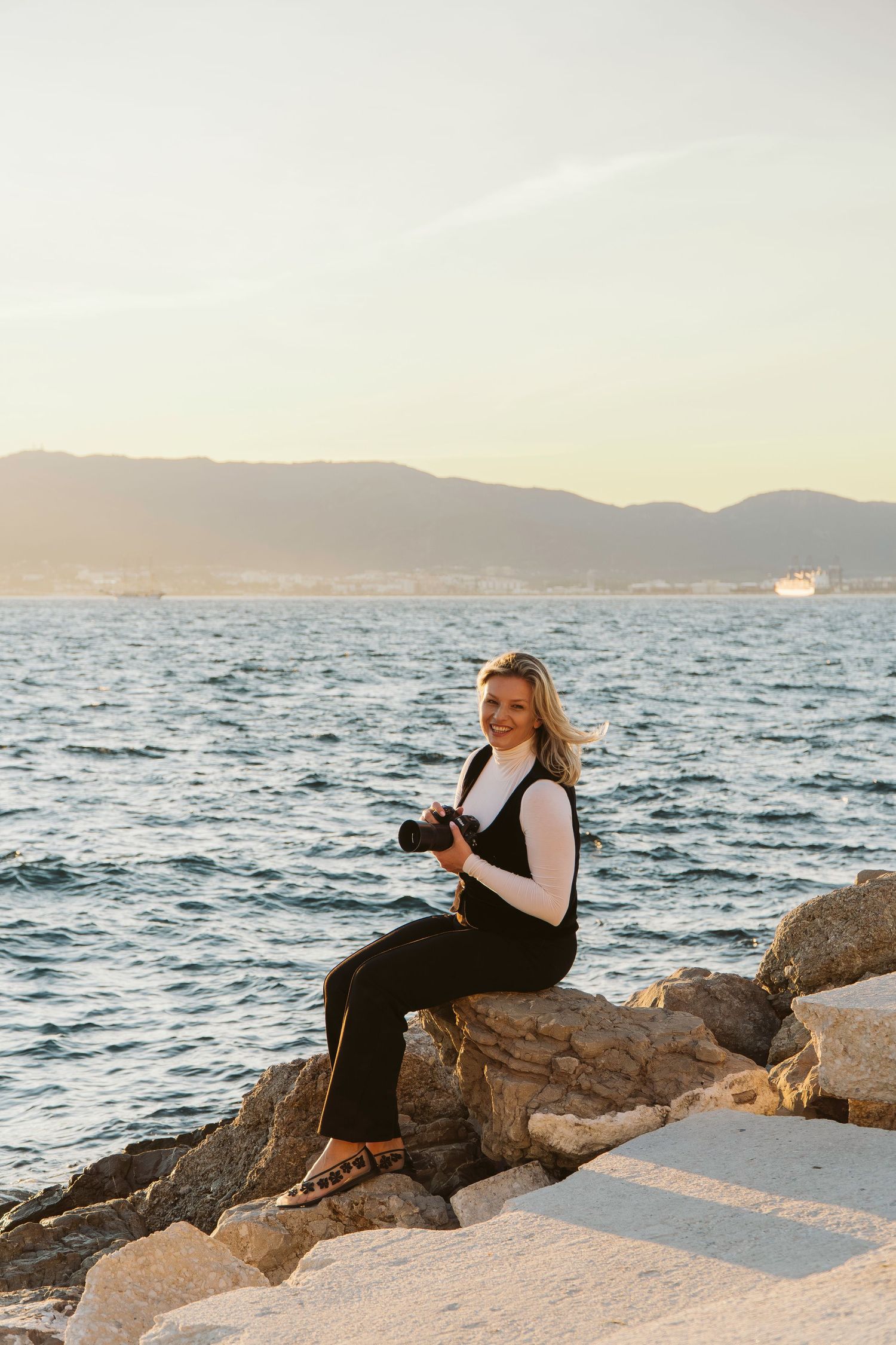 Anna Miel the photographer in Gibraltar posing for a photo with a camera