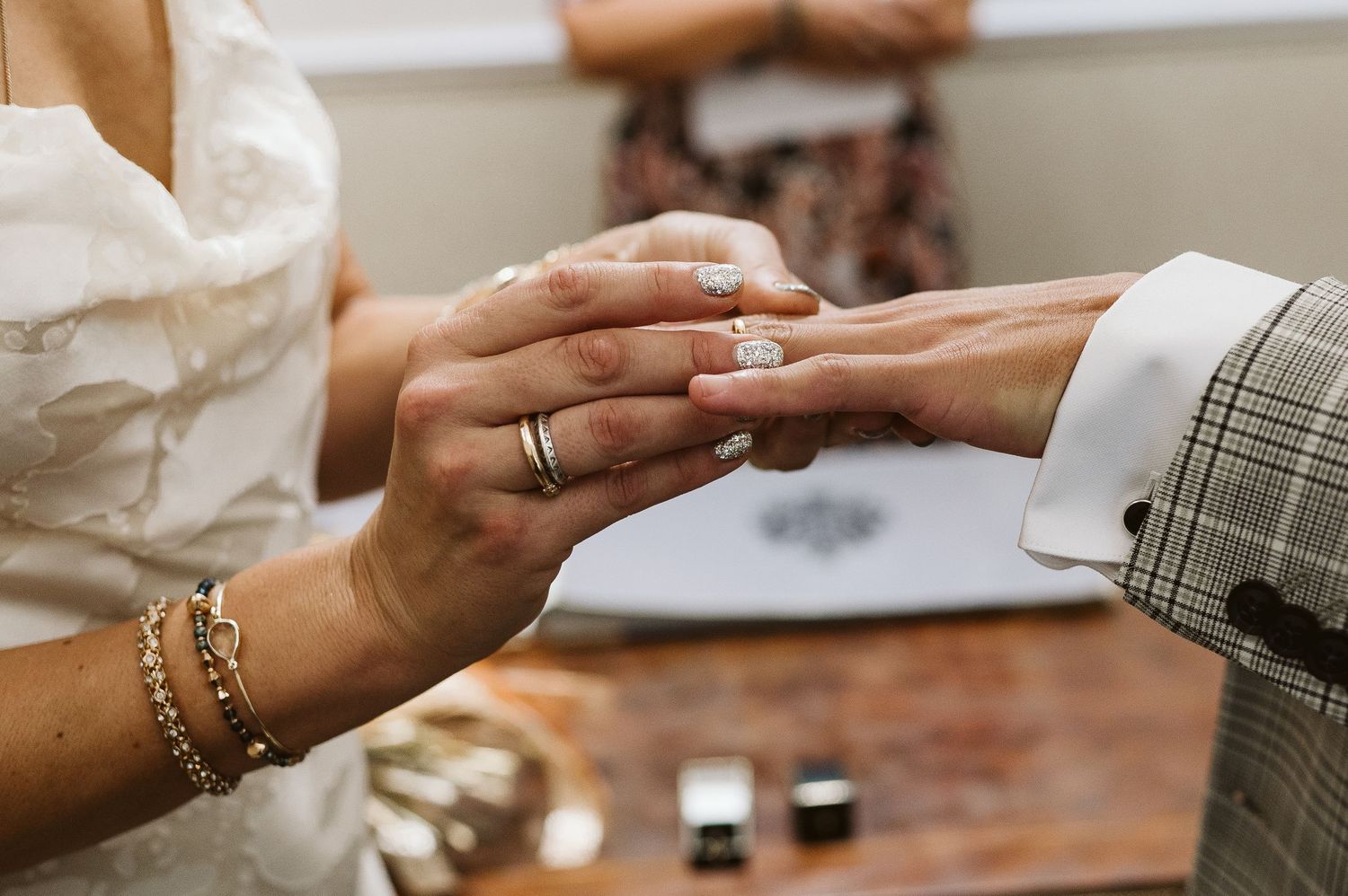 Bride putting the ring on grooms finger