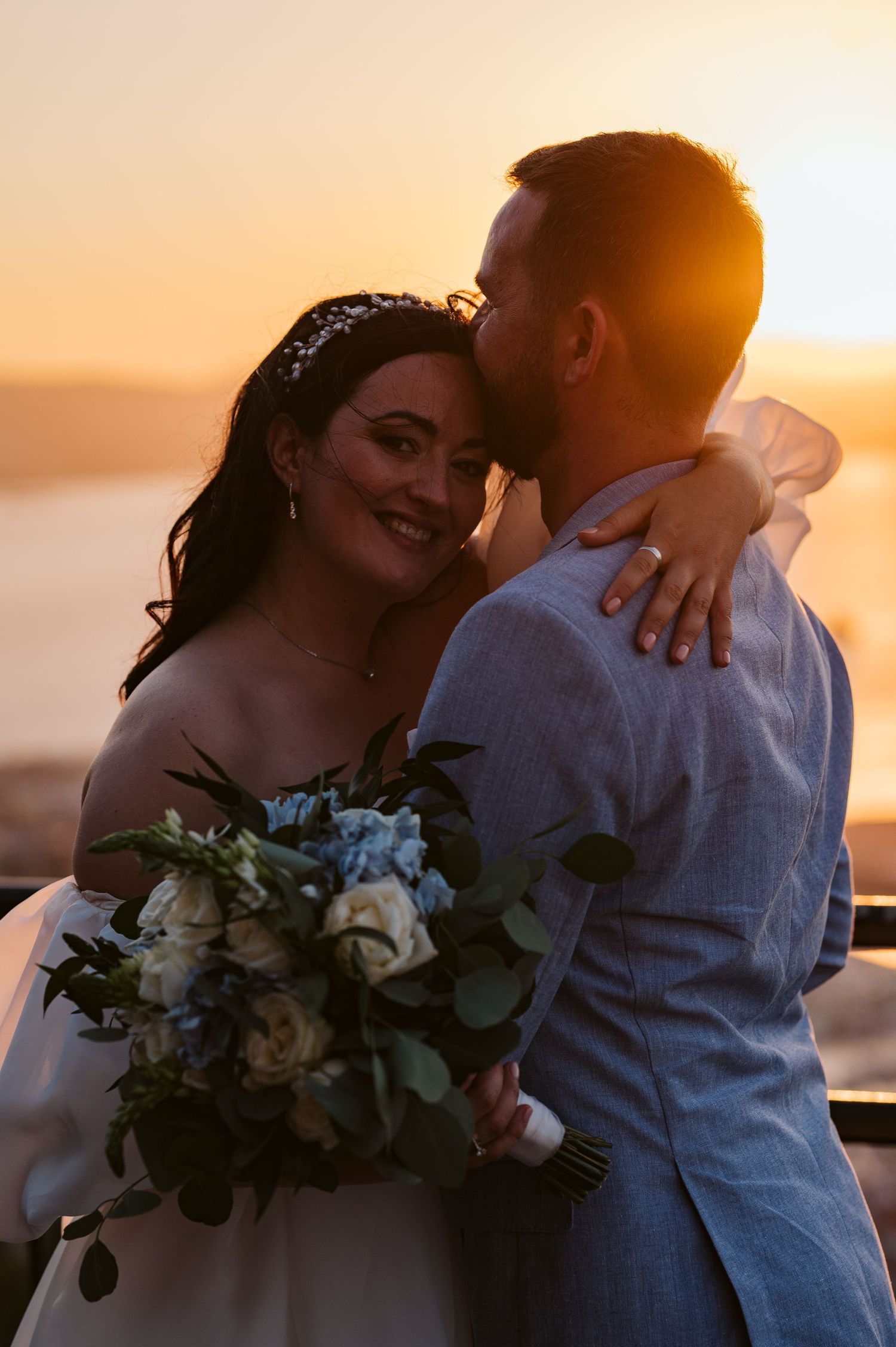 Bride hugging her husband in sunset light