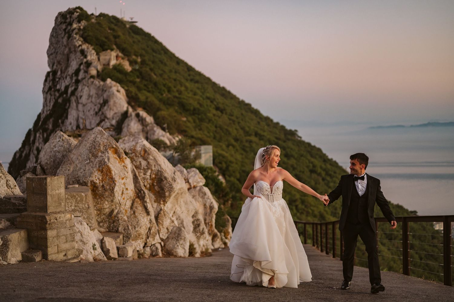 Bride and groom running on top of the Rock