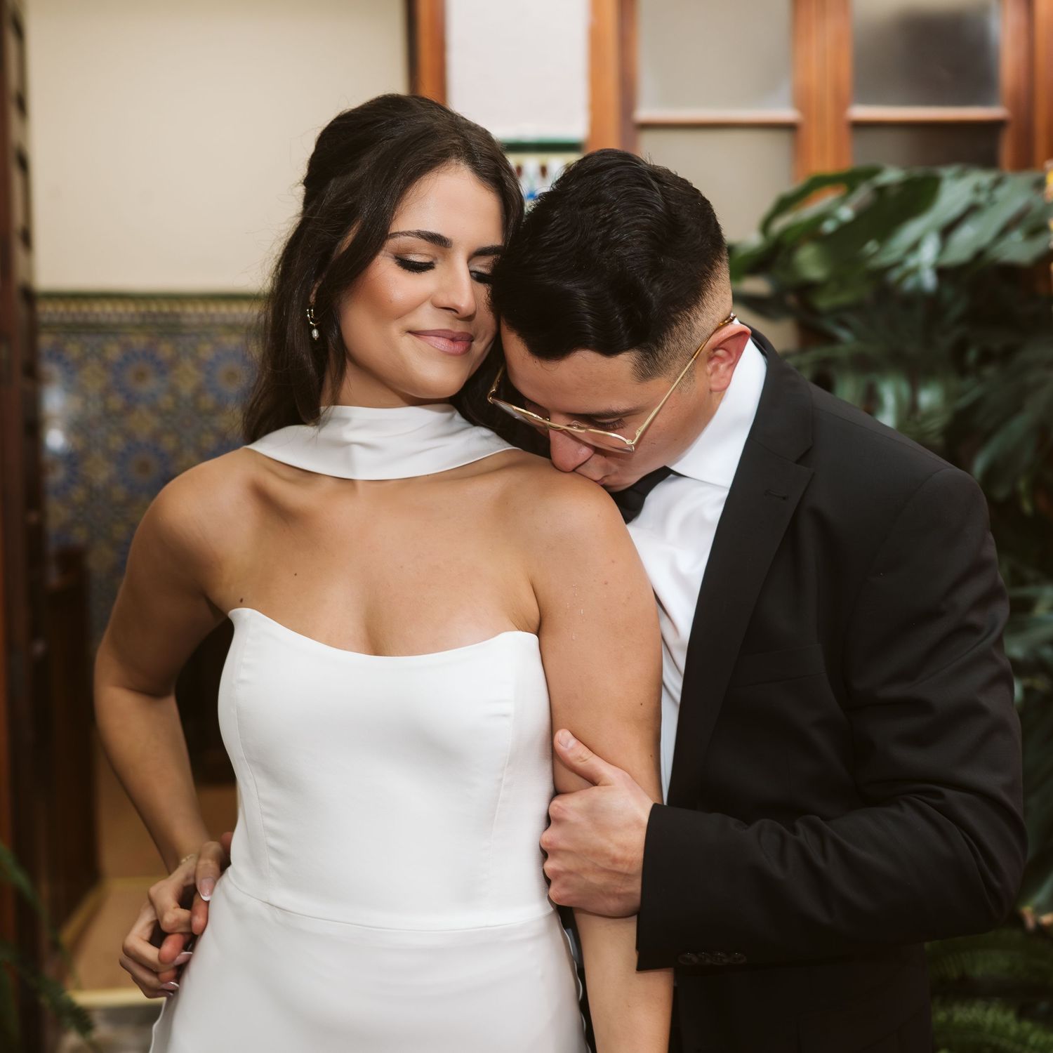 groom kissing the bride on her shoulder