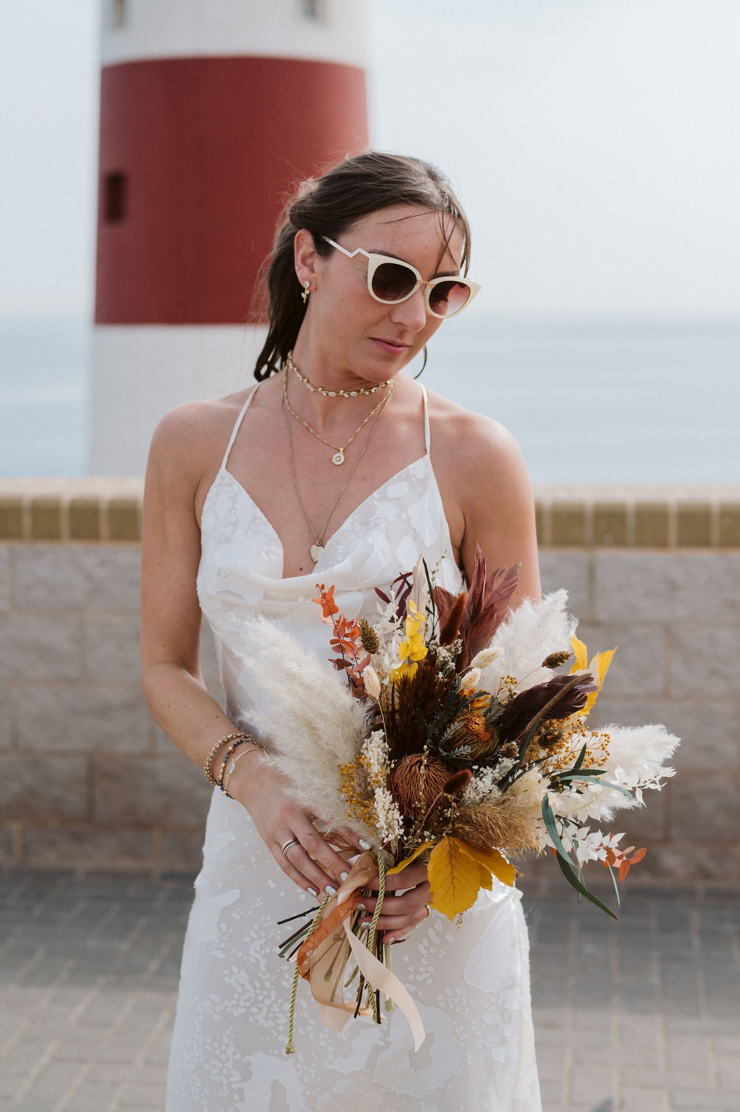 bride at the Lighthouse standing looking at the flowers