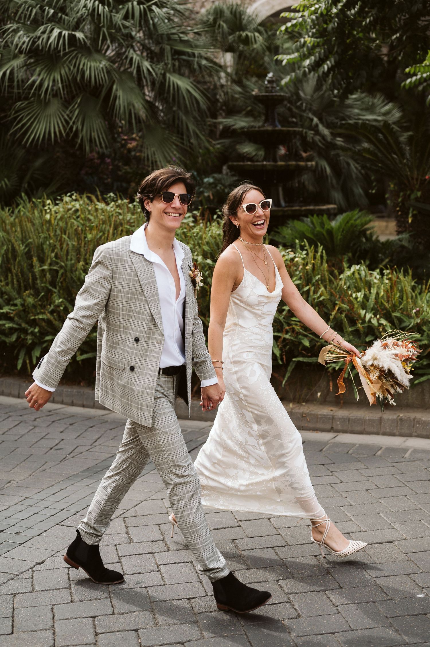 The wedding couple walking smiling at the camera