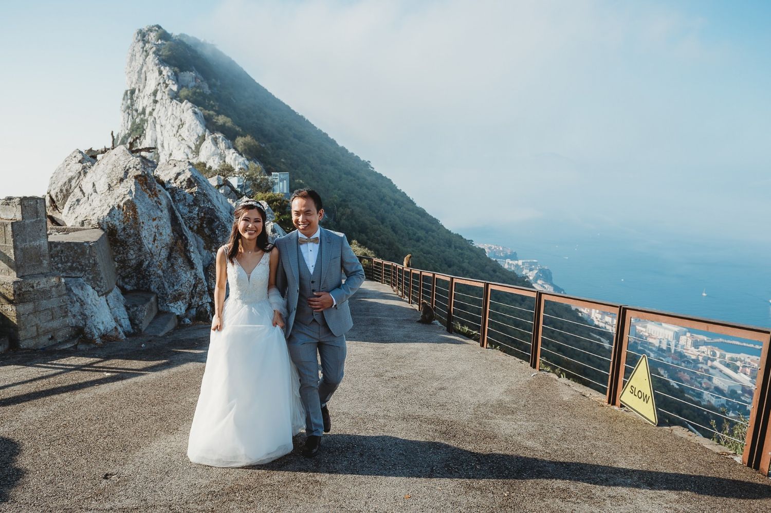 bride and groom walking in sunrise light in Gibraltar Top of the Rock