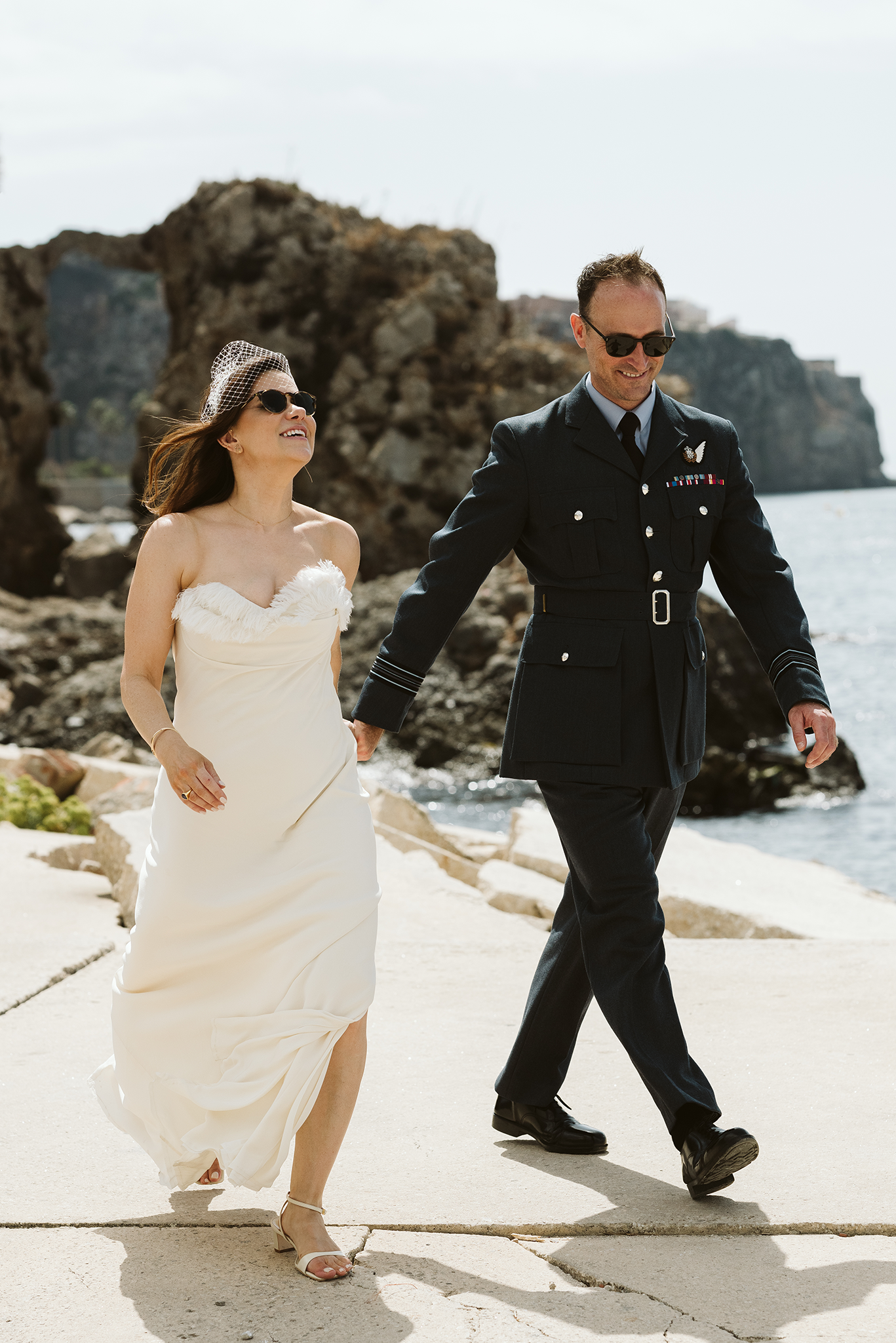 Bride walking with the groom at the Rosia Bay in Gibraltar