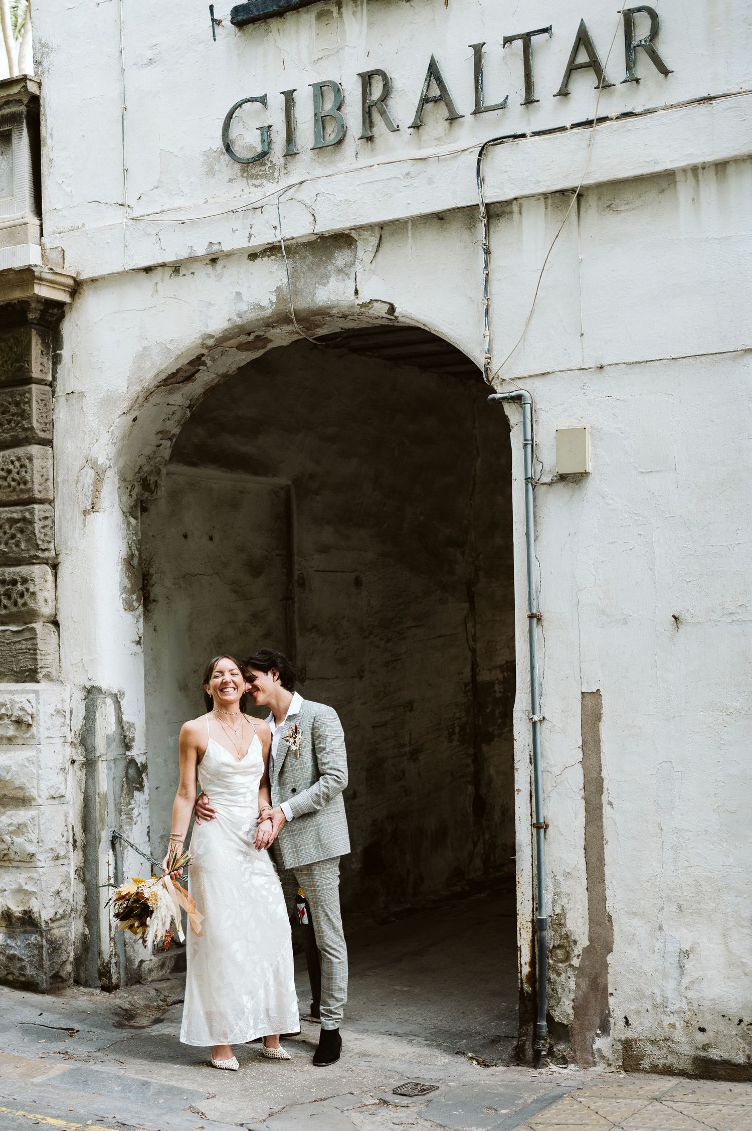 Groom kissing the bride at the Gibraltar sign