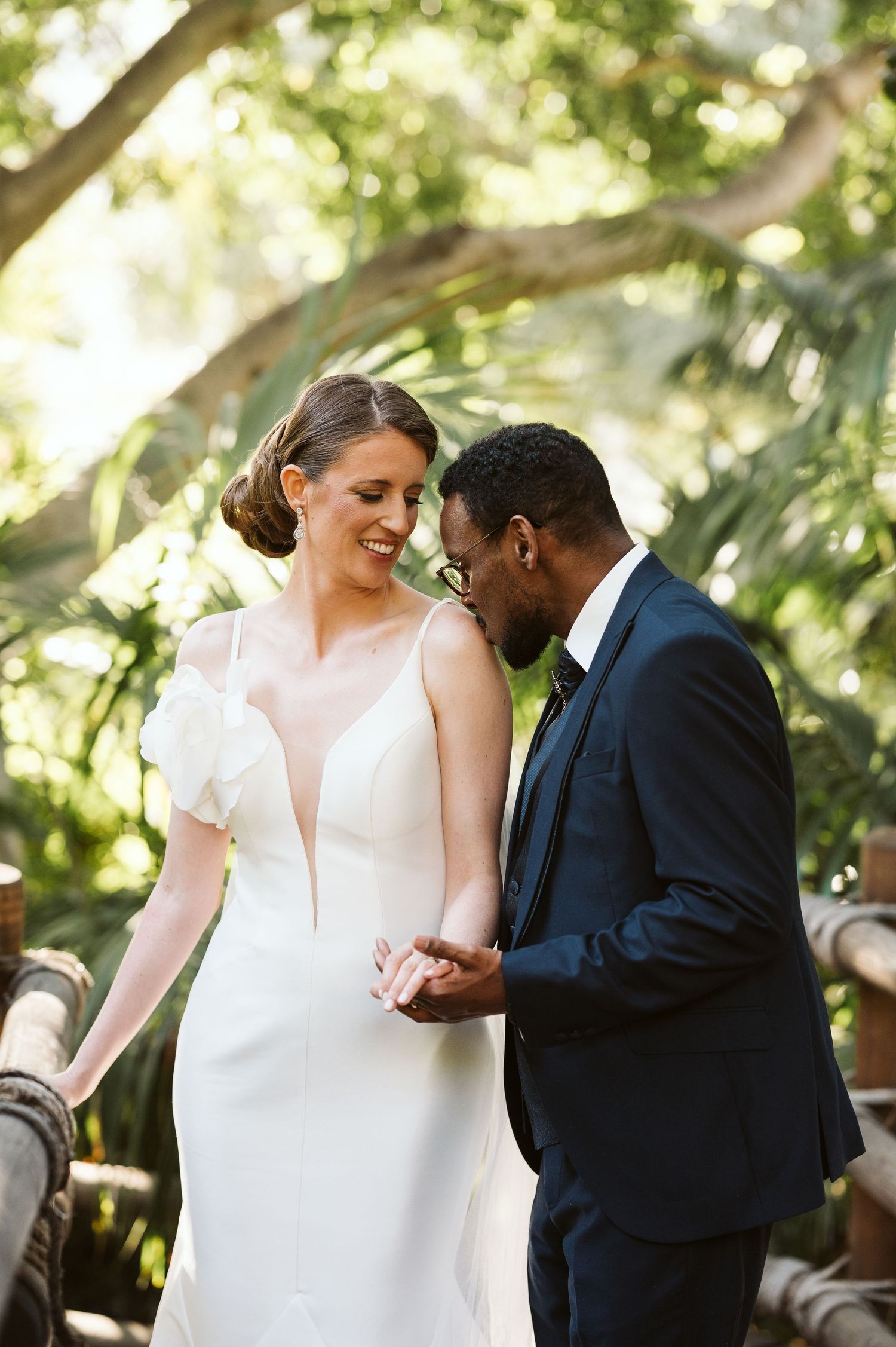 bride being kissed on the arm by the groom at the Alameda gardens