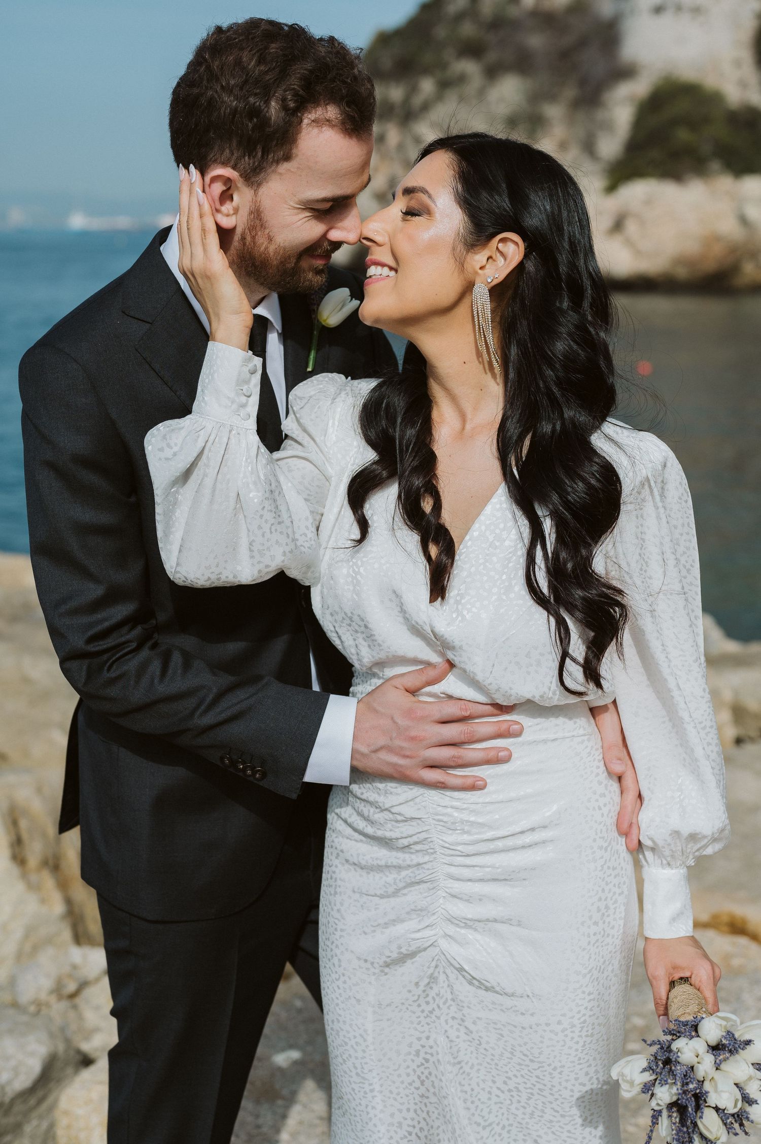bride holding the groom by the chin at Rosia Bay