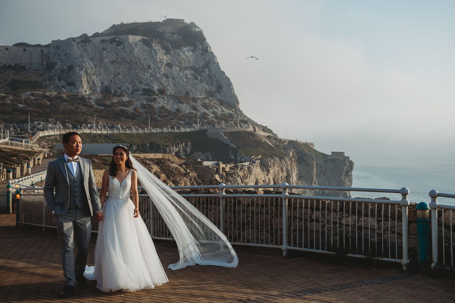 Bride and groom walking at Europa Point with beautiful light and view