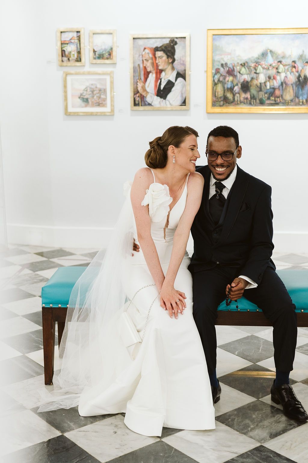 Bride laughing in the gallery trying to kiss the groomn