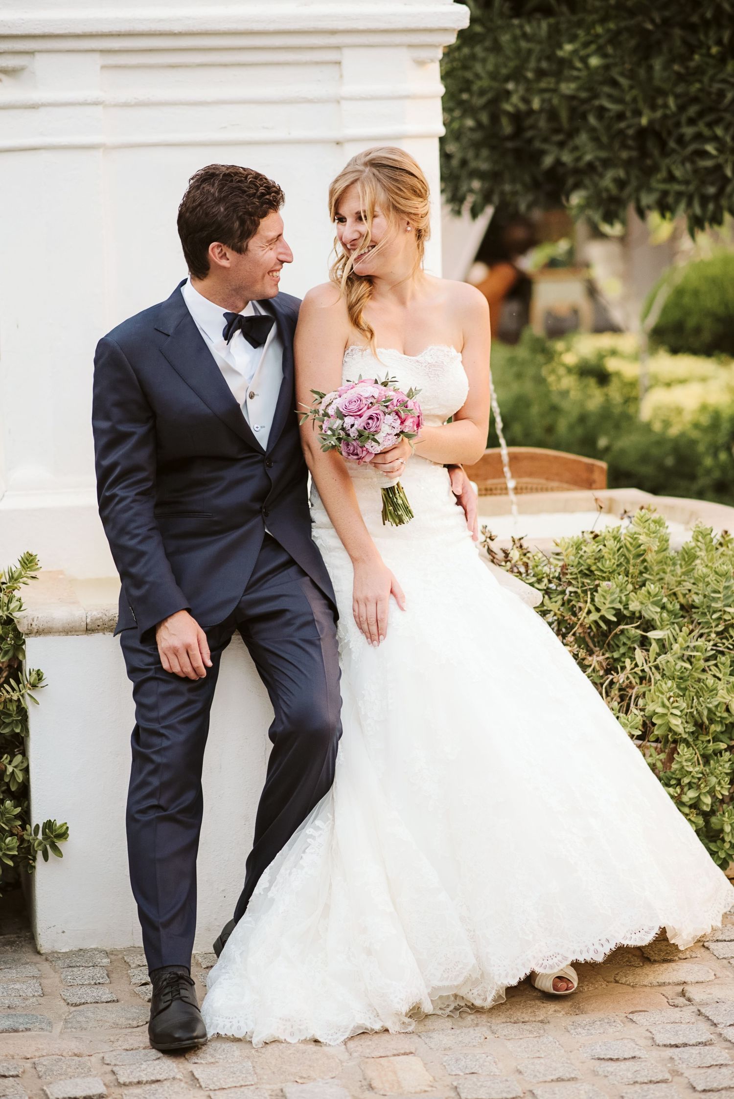 Bride and groom sitting by the fountain