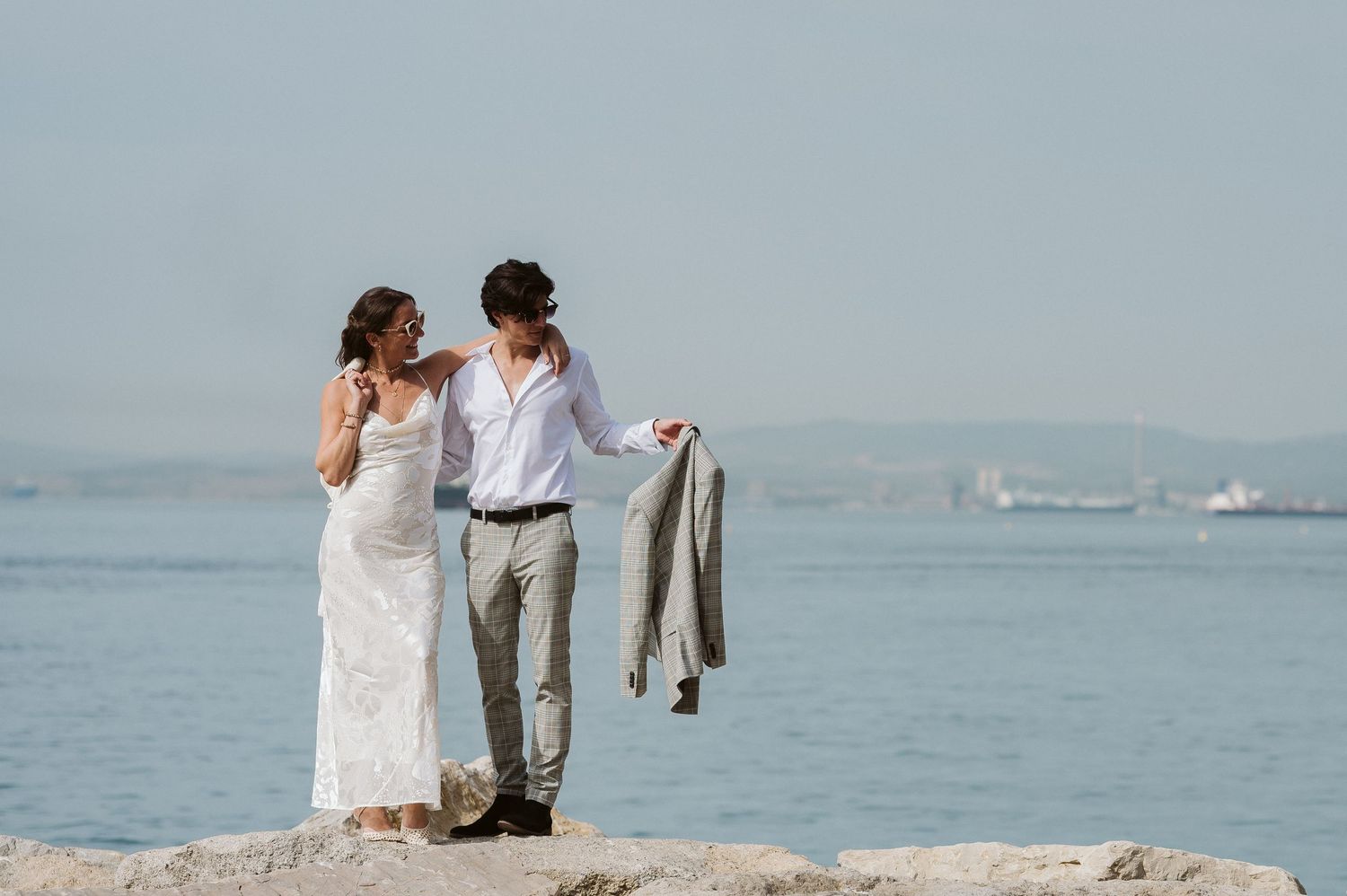 groom holding his suit jacket in a nice photo at Camp bay in Gibraltar