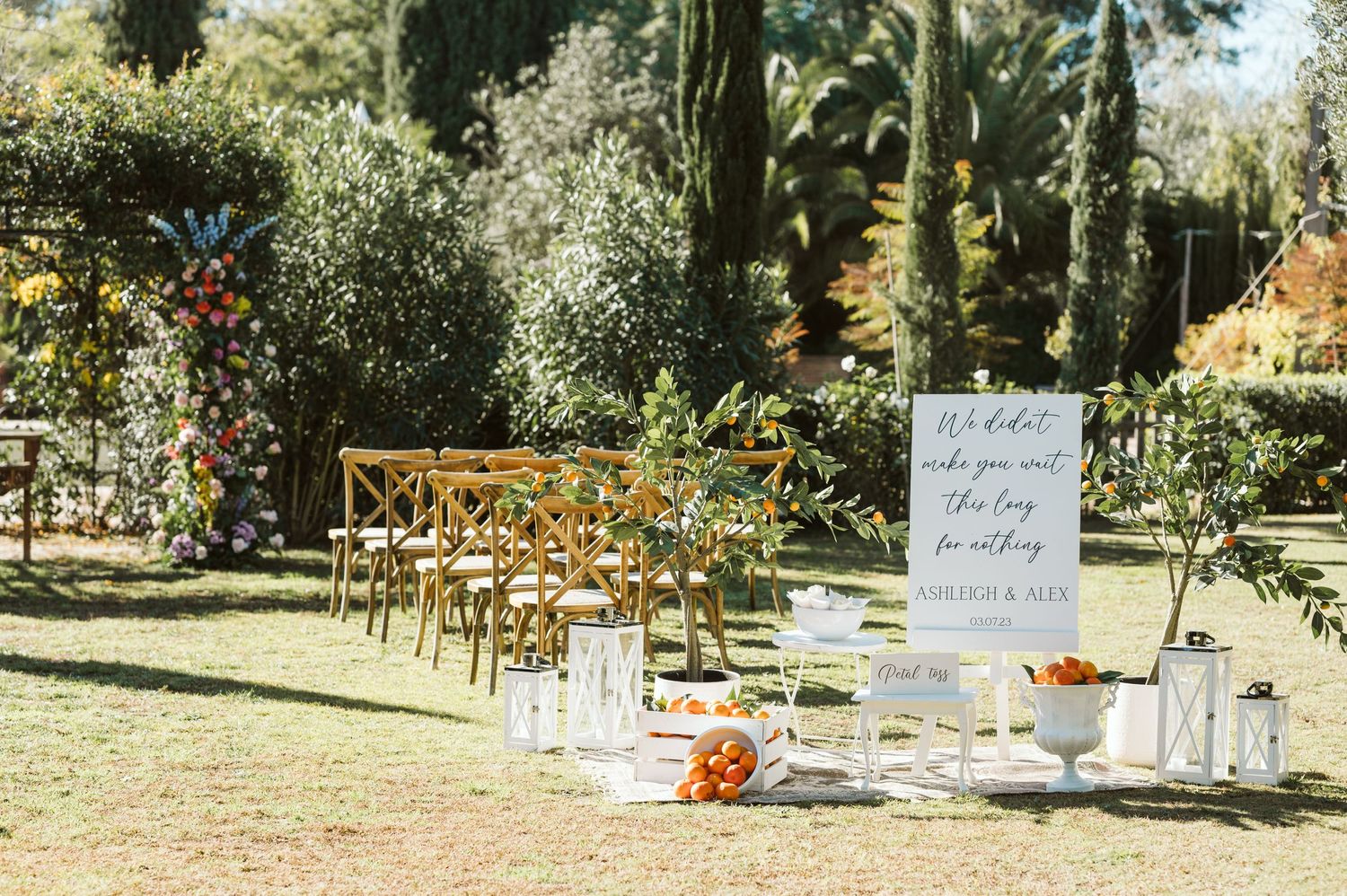 Beautiful setup of oranges and flowers with wooden chairs for a wedding