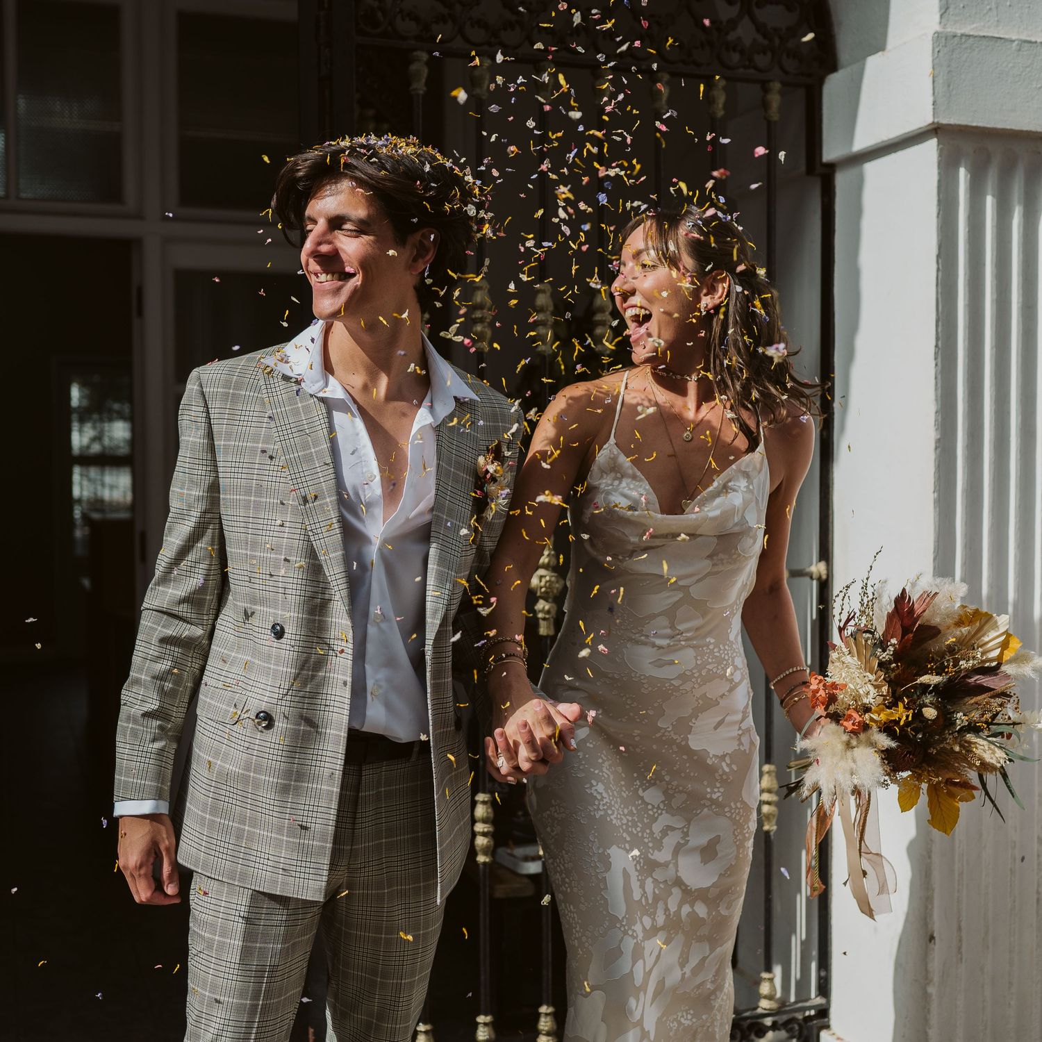 petals confetti and groom and bride laughing