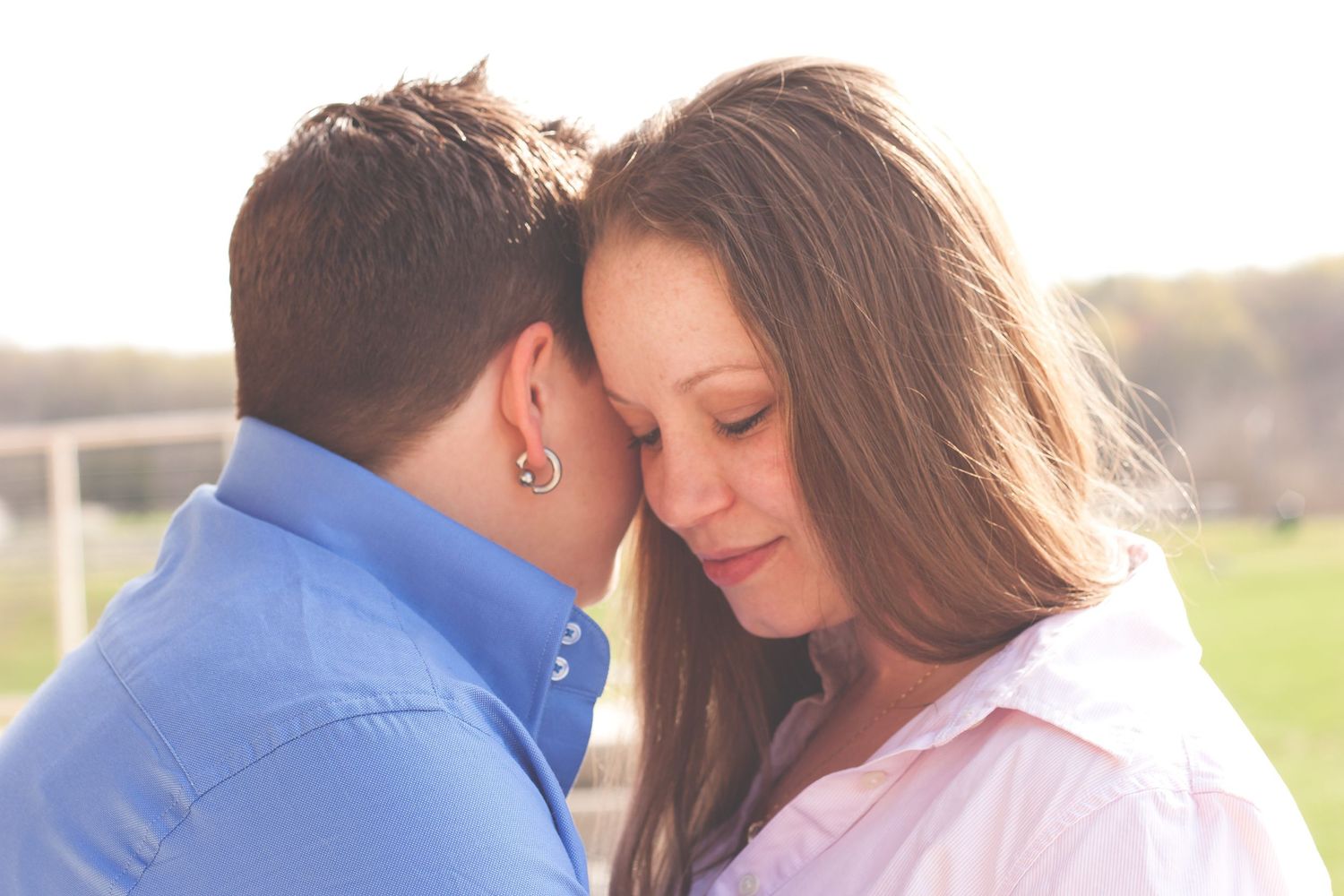 Engaged couple sharing an intimate moment outdoors.