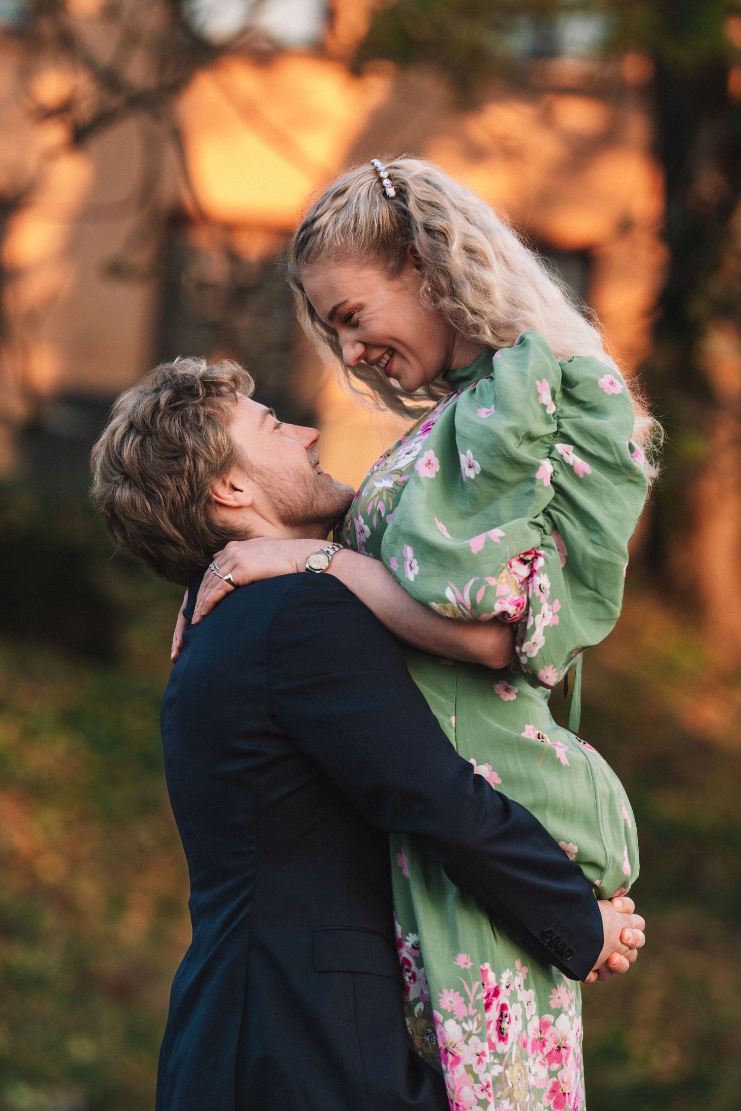 A romantic couple embraces in a sunset-lit park, creating a series of intimate dance-like movements.