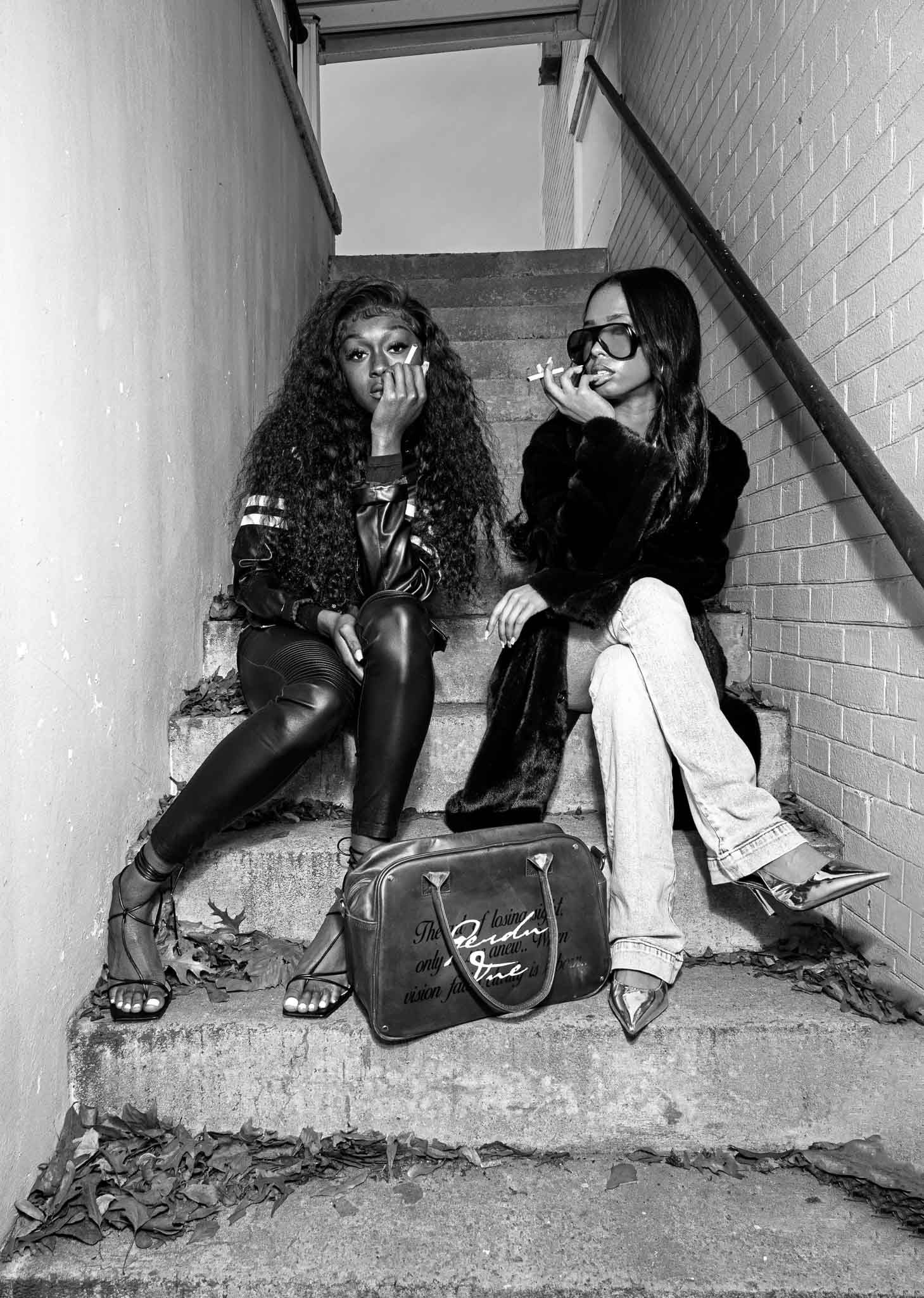 People sitting together in a dimly lit concrete stairwell.
