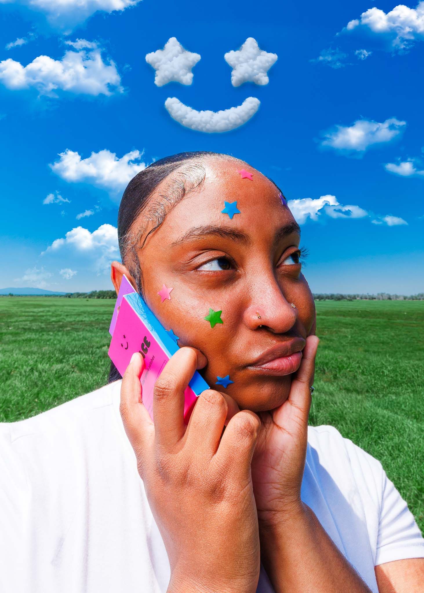 Young woman with colorful Starface star pimple patches on face holding pink phone under cloud smiley face sky.