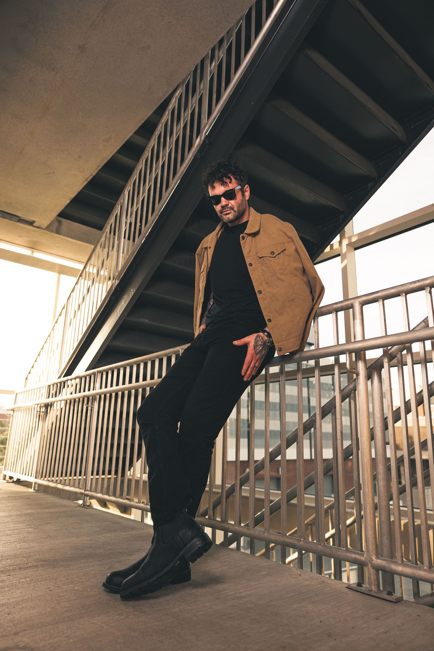 Person in brown jacket posing along industrial railings in various dramatic angles.