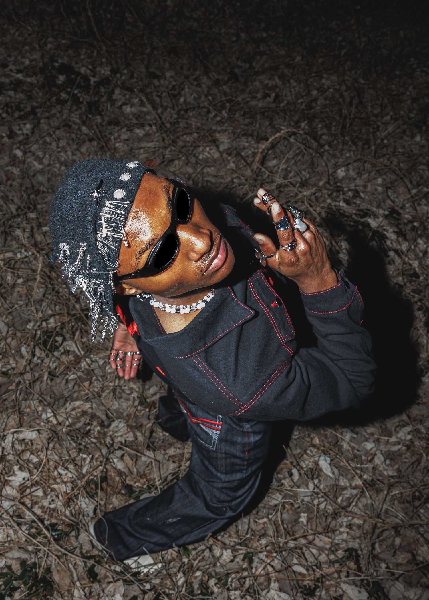 High-angle editorial streetwear portrait photographed at night, highlighting expressive fashion styling and cinematic lighting.