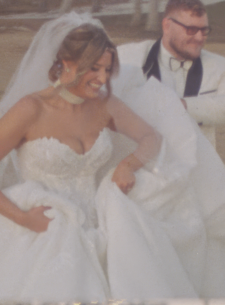 A couple celebrates during a wedding ceremony with the bride wearing a sweetheart neckline gown and flowing veil.
