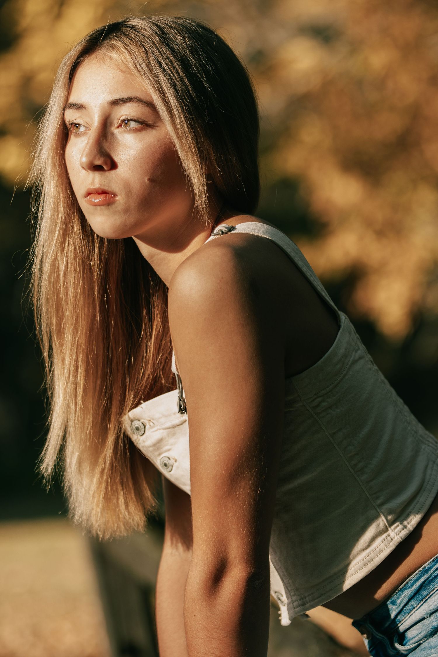 A fashion portrait series shows a person posing in a black top against a warm autumn background.