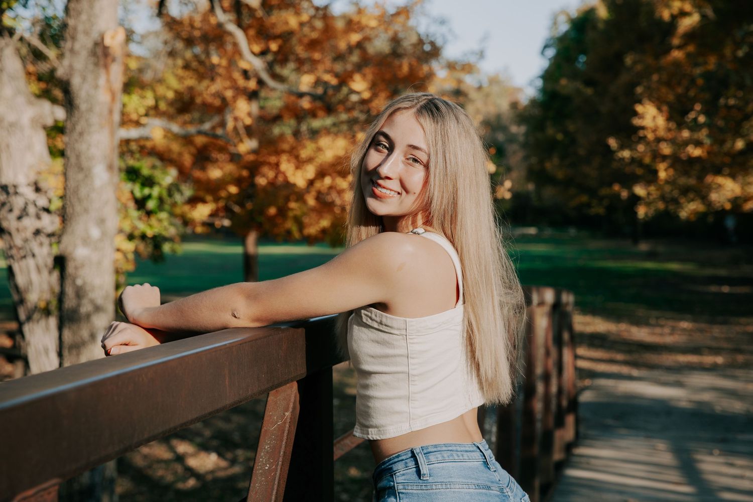A collage of outdoor autumn portraits showing someone posing against trees and a wooden railing in natural lighting.