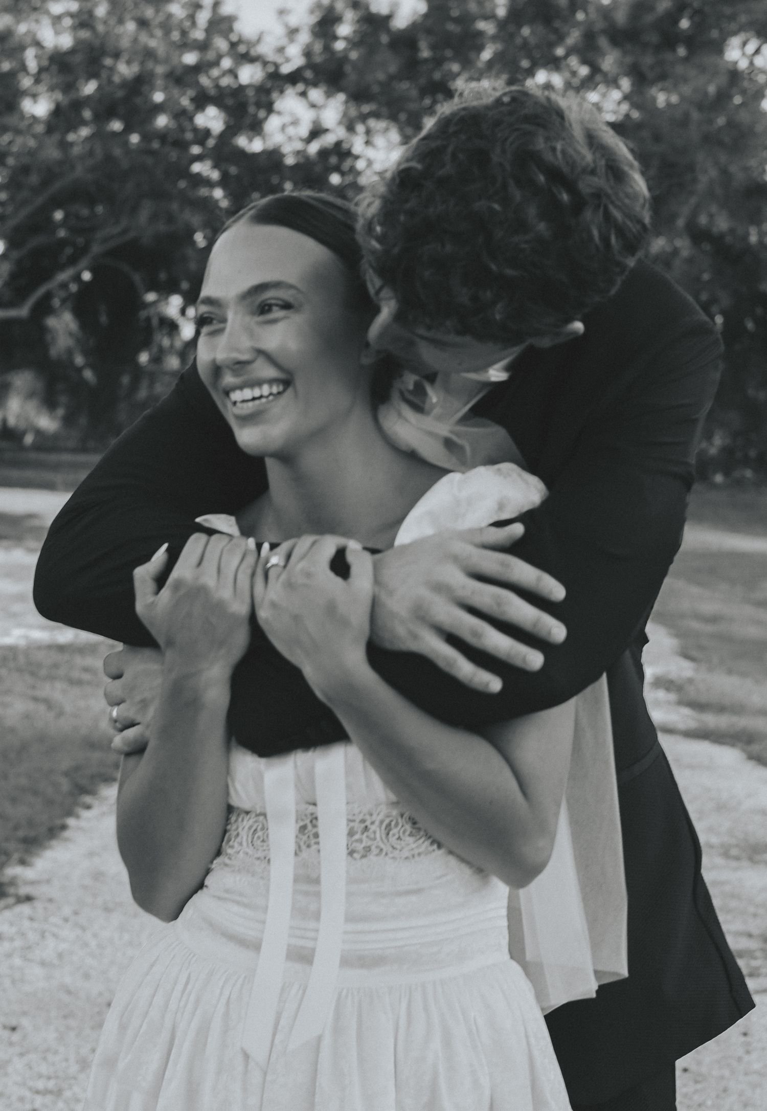 A series of black and white photos showing a couple embracing in a romantic moment outdoors.