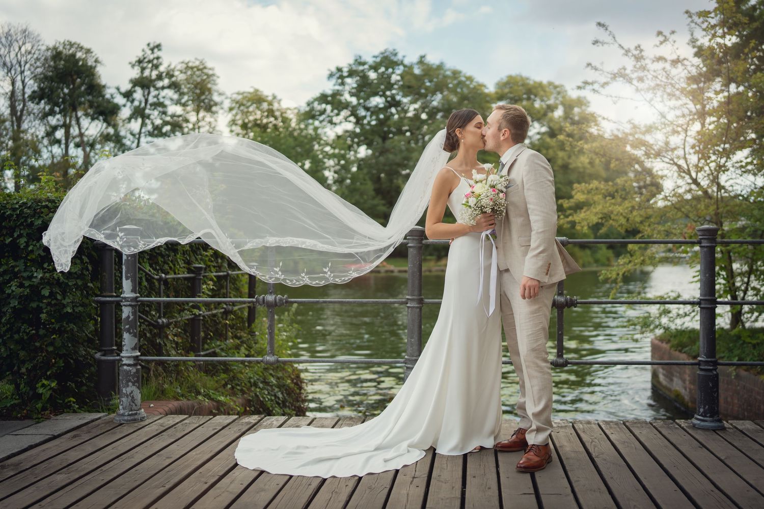 Hochzeitsfotograf Alt-Treptow Berlin – Brautpaar küsst sich am Wassersteg mit wehendem Schleier
