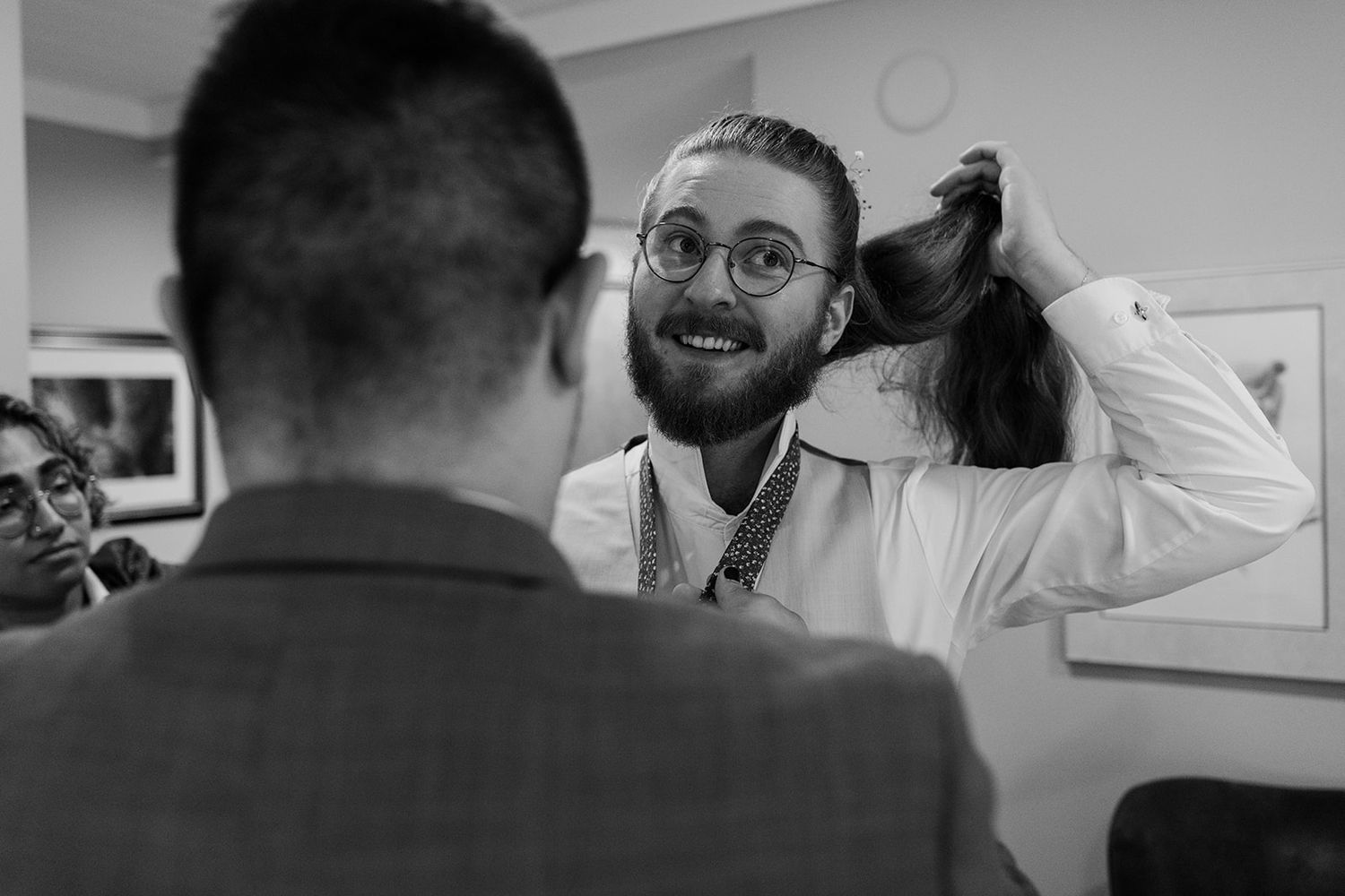 Wedding preparation scene in black and white with natural window lighting.