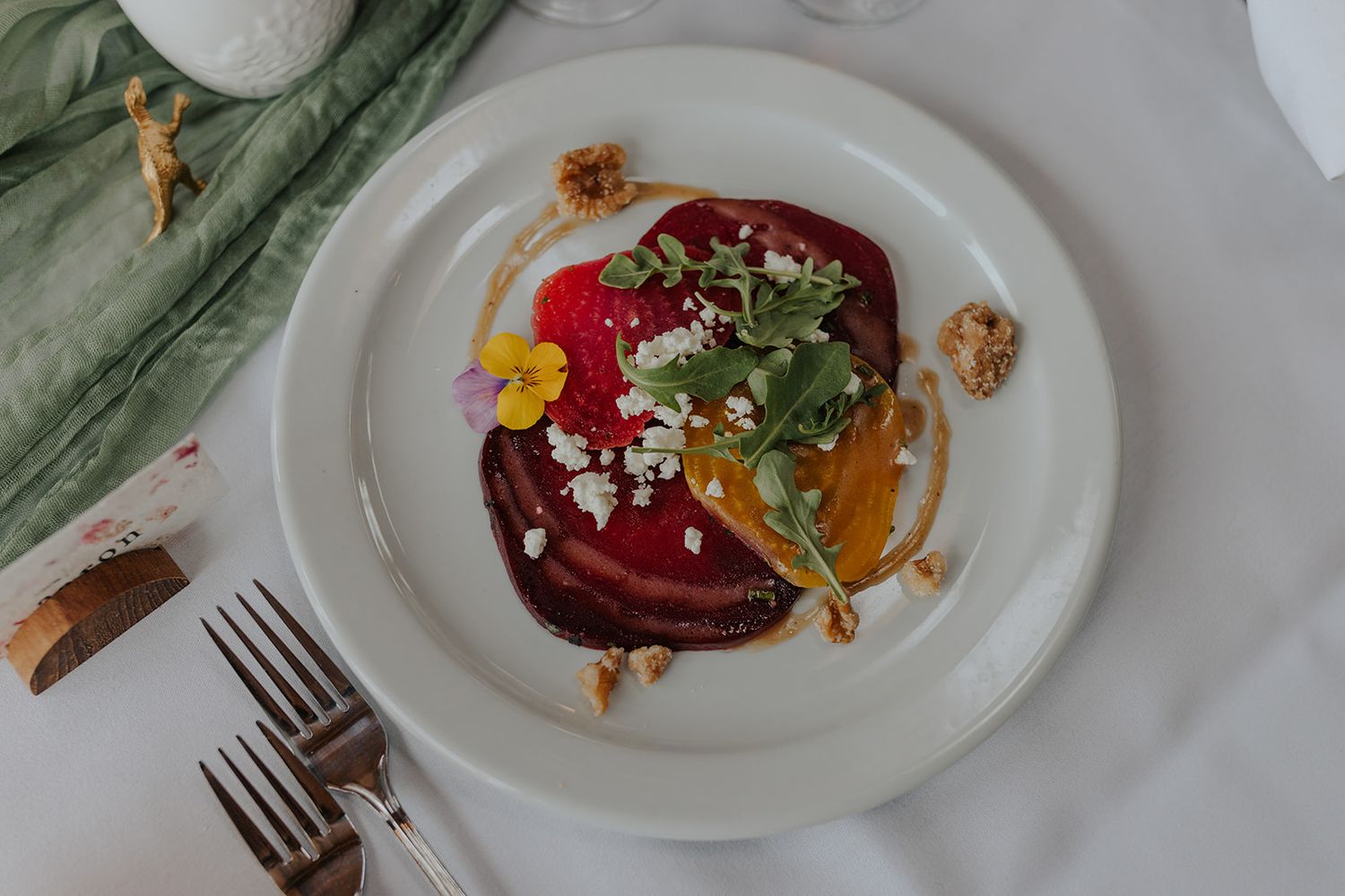Beautifully plated gourmet dishes on white plates with colorful garnishes and sauces.