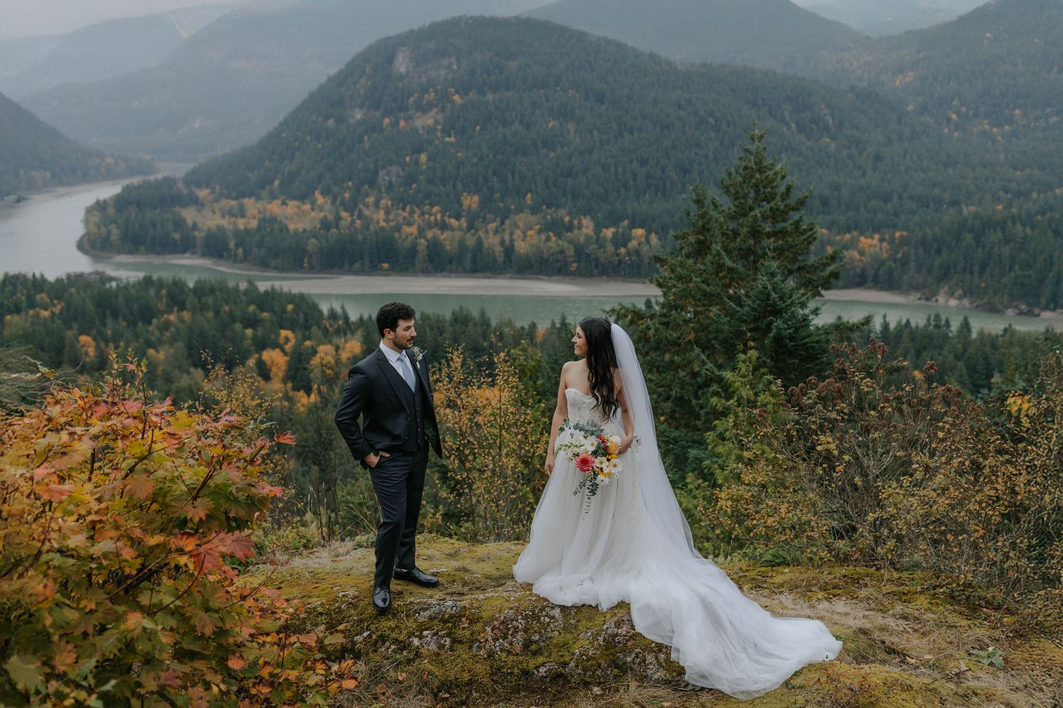 Mountain wedding ceremony with scenic autumn views of evergreen forests and distant peaks in the background.