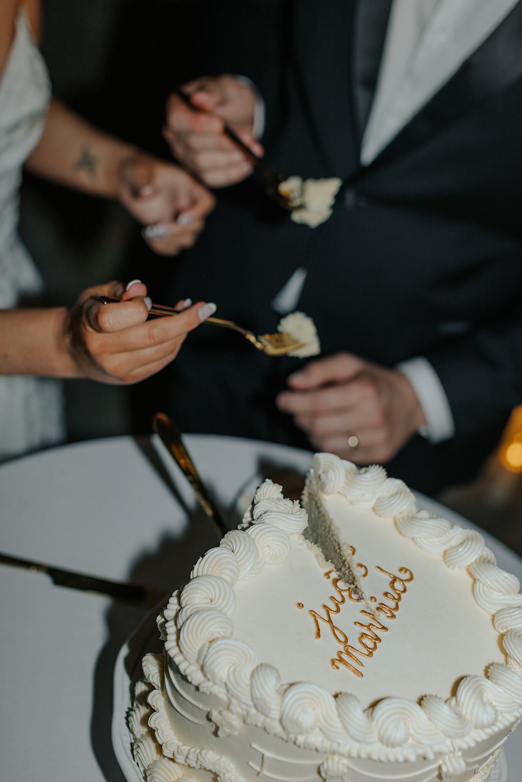 Close-up of wedding cake cutting with white frosted details.