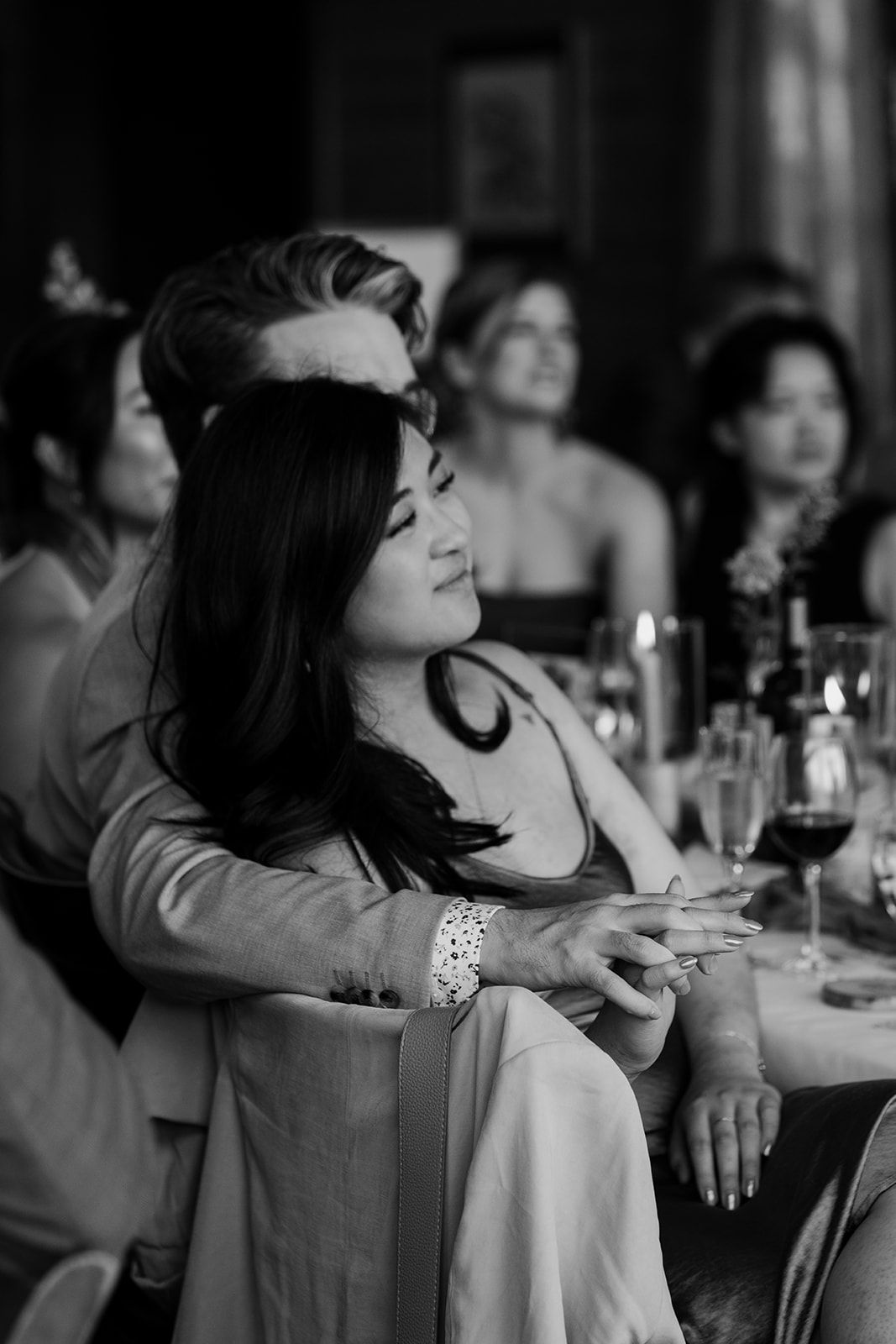 Guest in elegant attire relaxes with wine glass during reception.