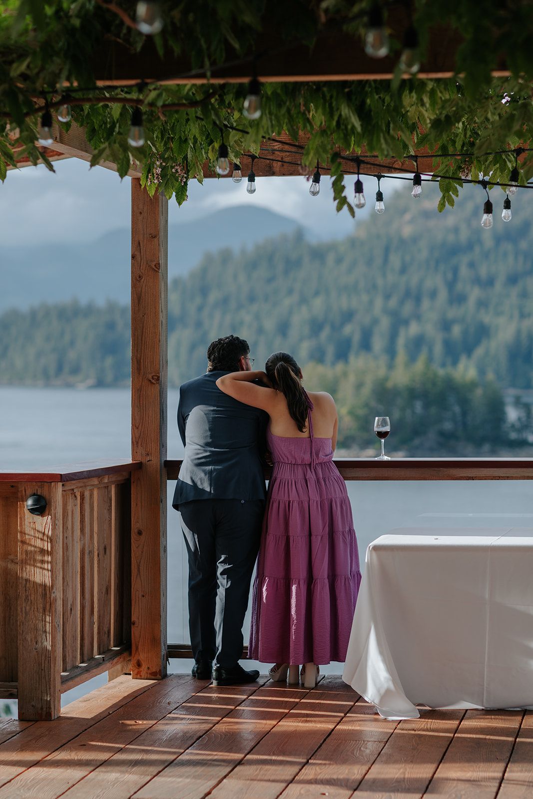 Wedding reception on a covered deck overlooking a serene mountain lake.