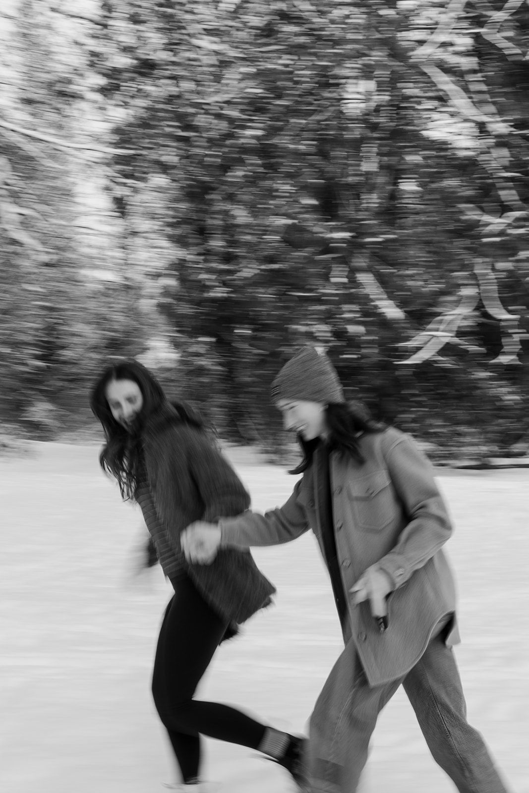 A couple runs and plays together in a snowy winter landscape.