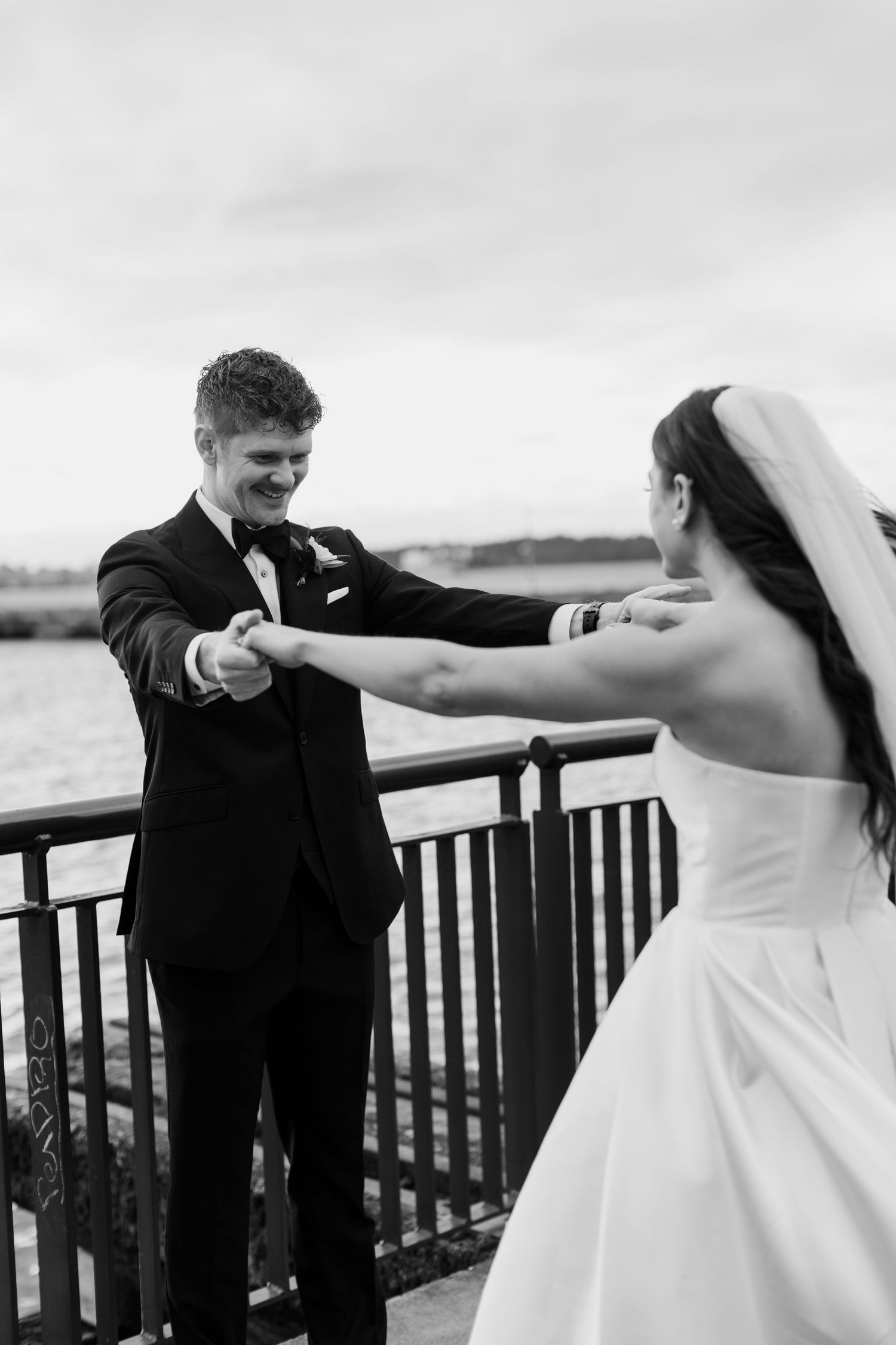 A playful sequence of wedding photos showing a couple dancing and twirling on a waterfront deck.