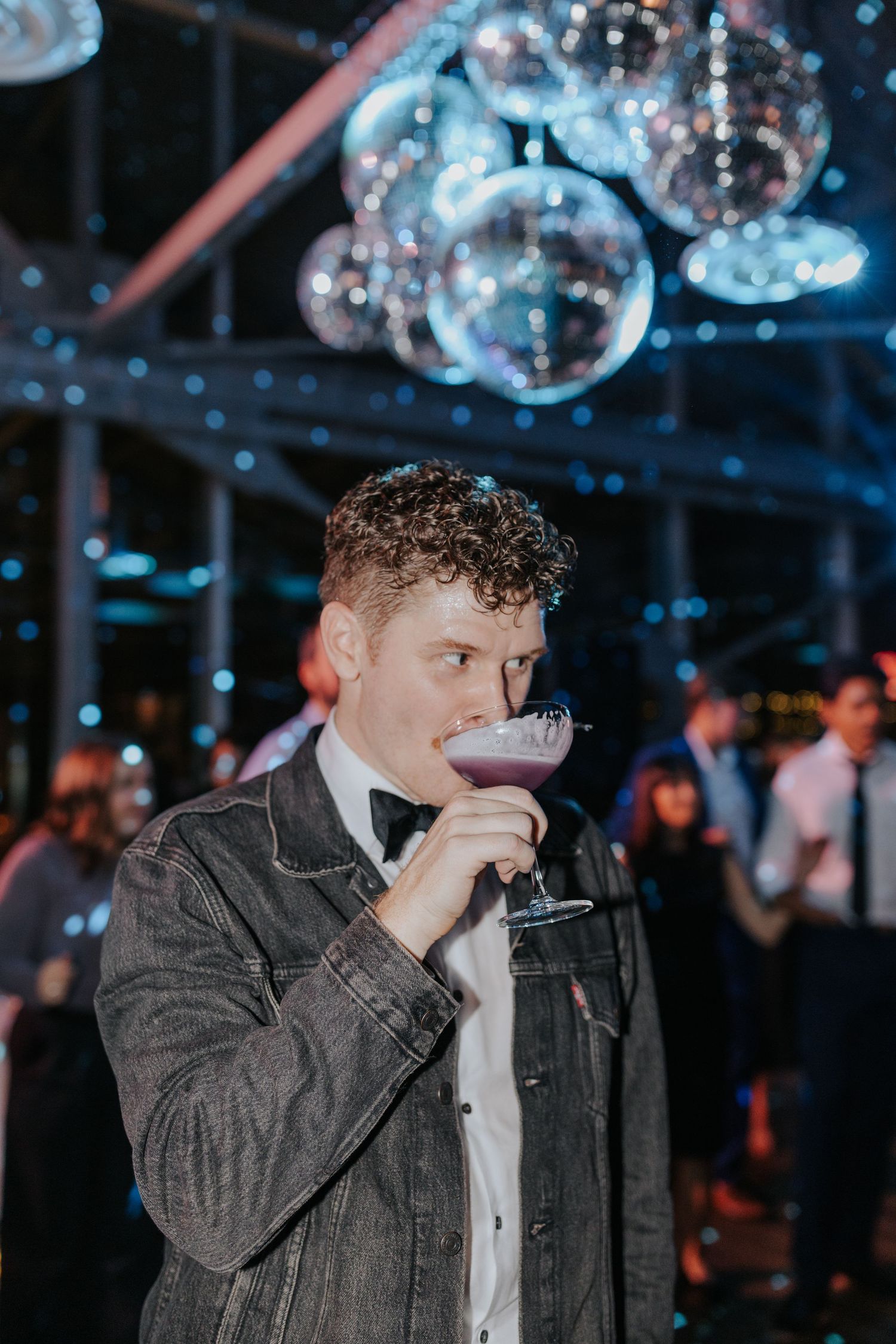 Party scene with disco balls and blue lighting creating a moody atmosphere.