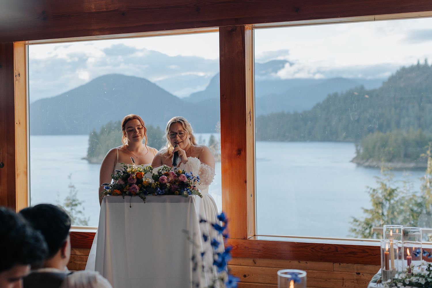 Panoramic mountain and lake views through floor-to-ceiling windows in a wedding venue.