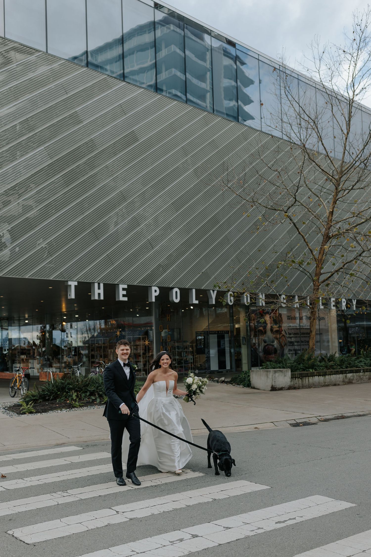 Modern wedding couple walking outside The Polygon gallery building with geometric architecture.