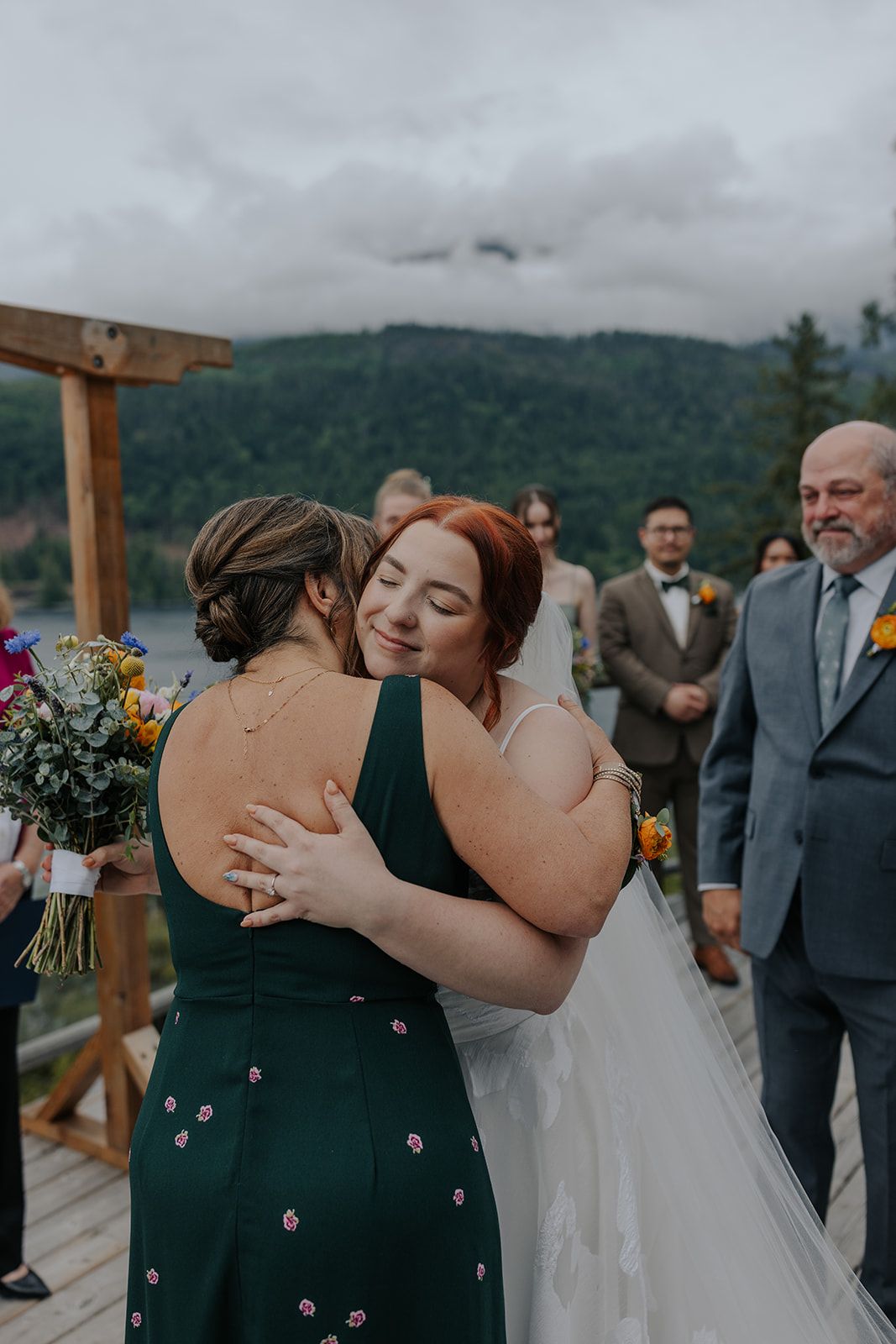 Intimate wedding moments shared between bride and wedding party on outdoor deck.